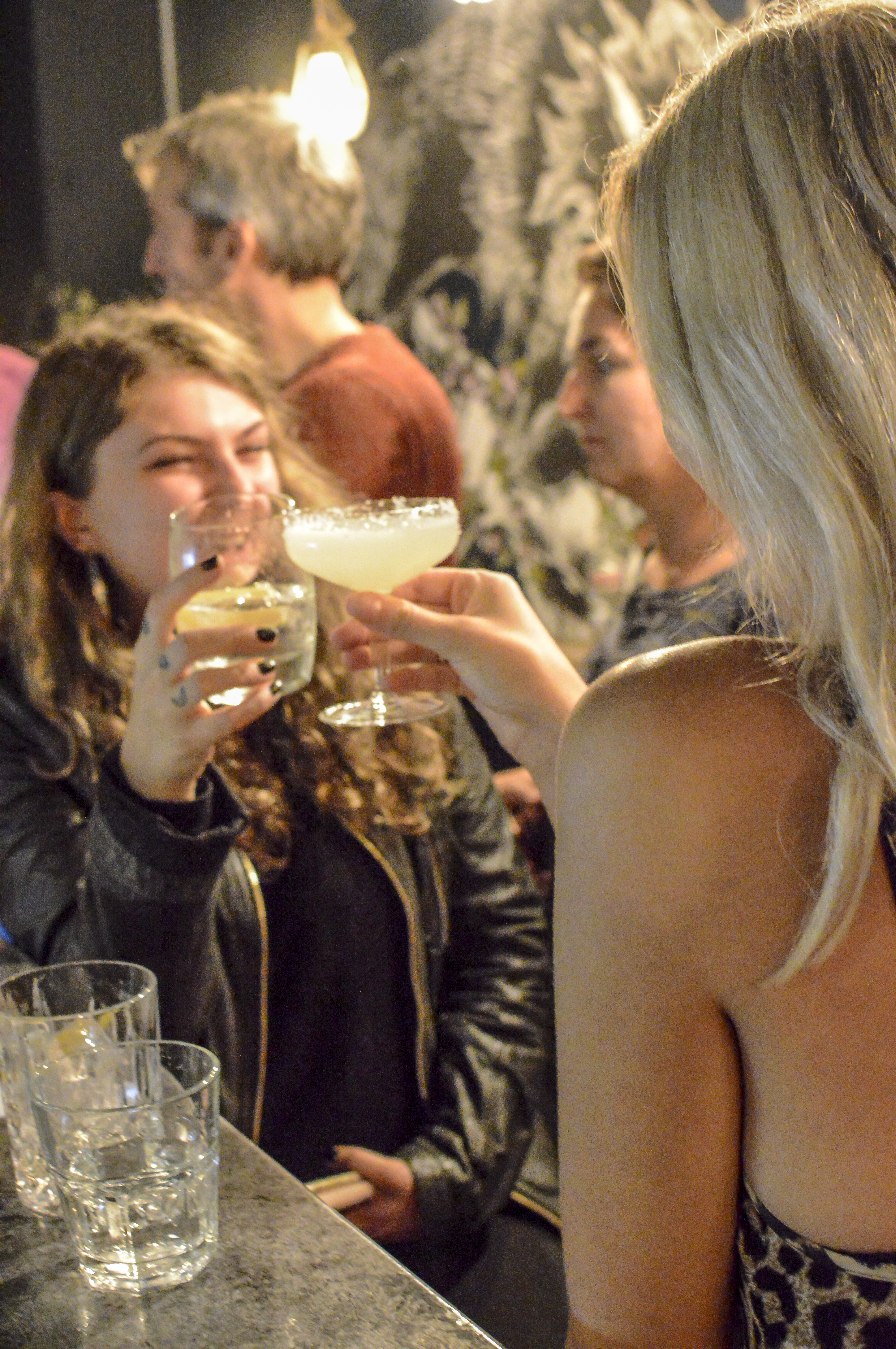 Lively BATCH Cocktail Bar gathering with clinking glasses for networking events.