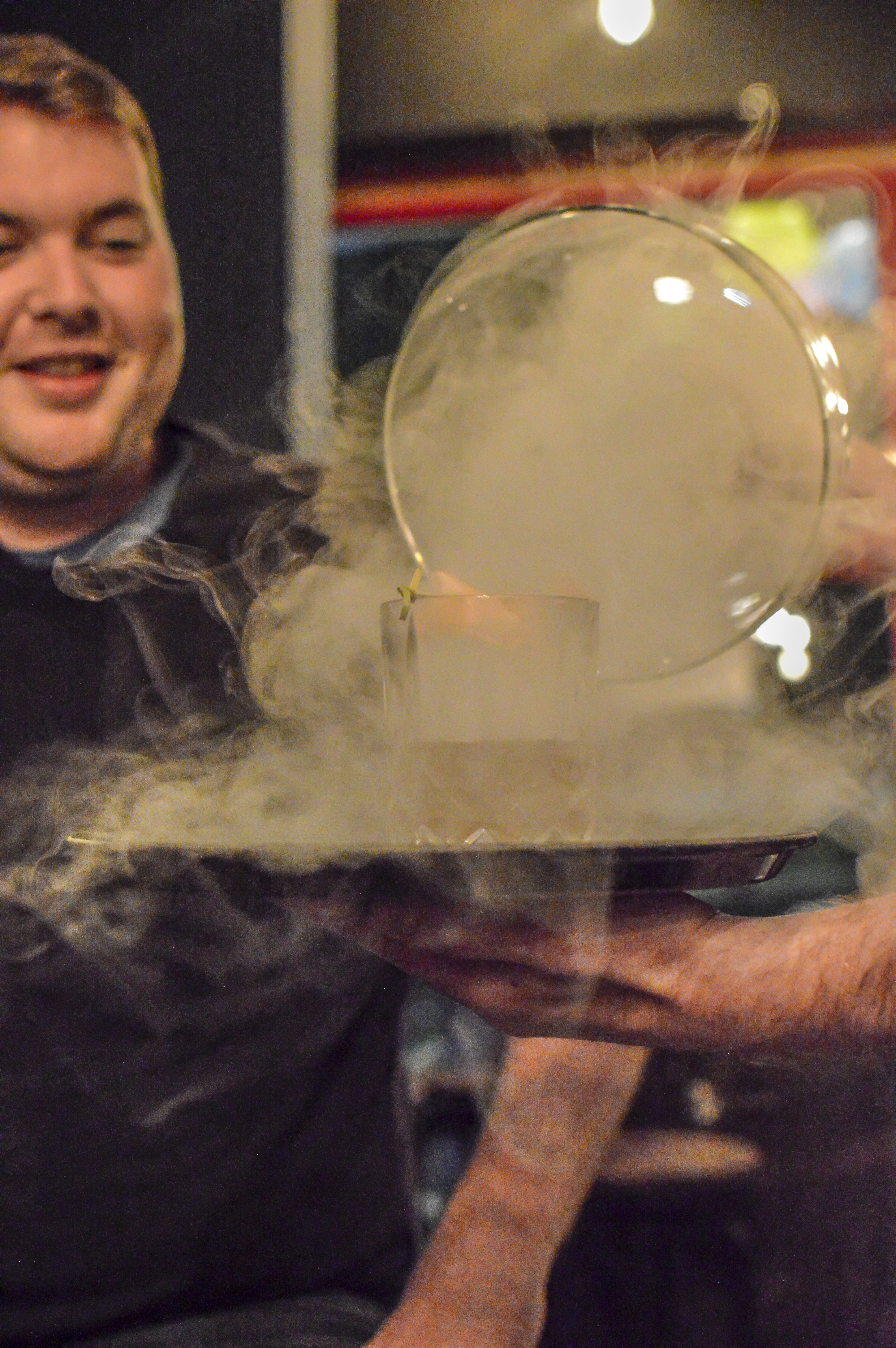 Creative cocktail presentation with smoke under glass dome at BATCH Cocktail Bar.