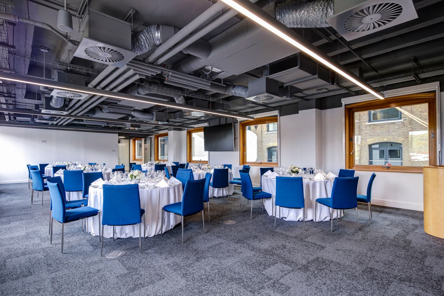 Modern event space with round tables, ideal for corporate meetings and formal gatherings.