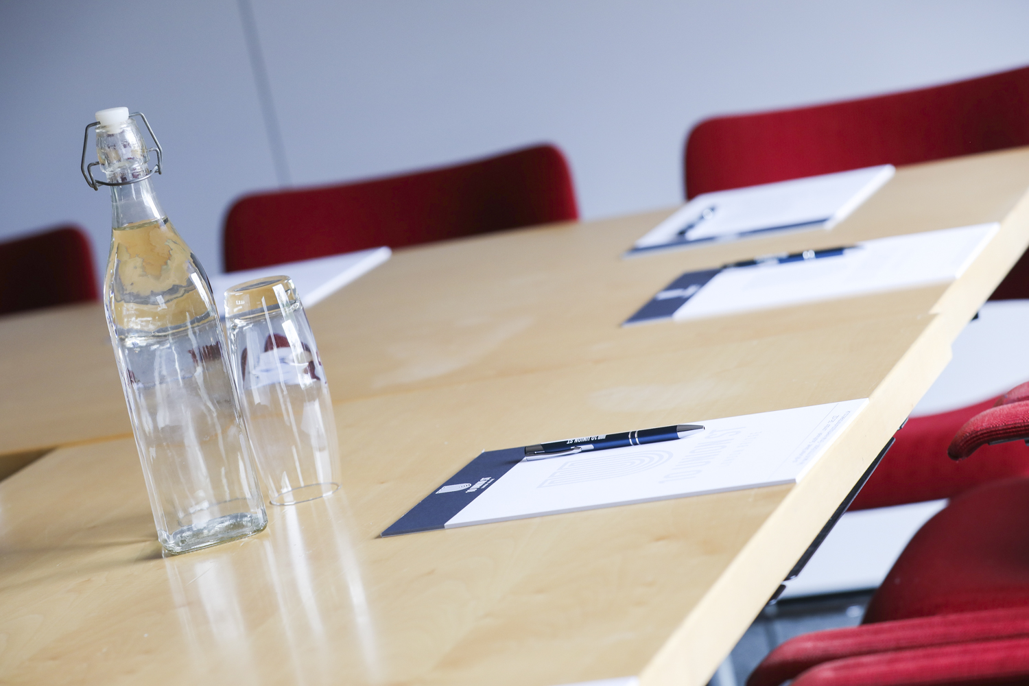 Meeting space with polished wooden table and red chairs for productive discussions.