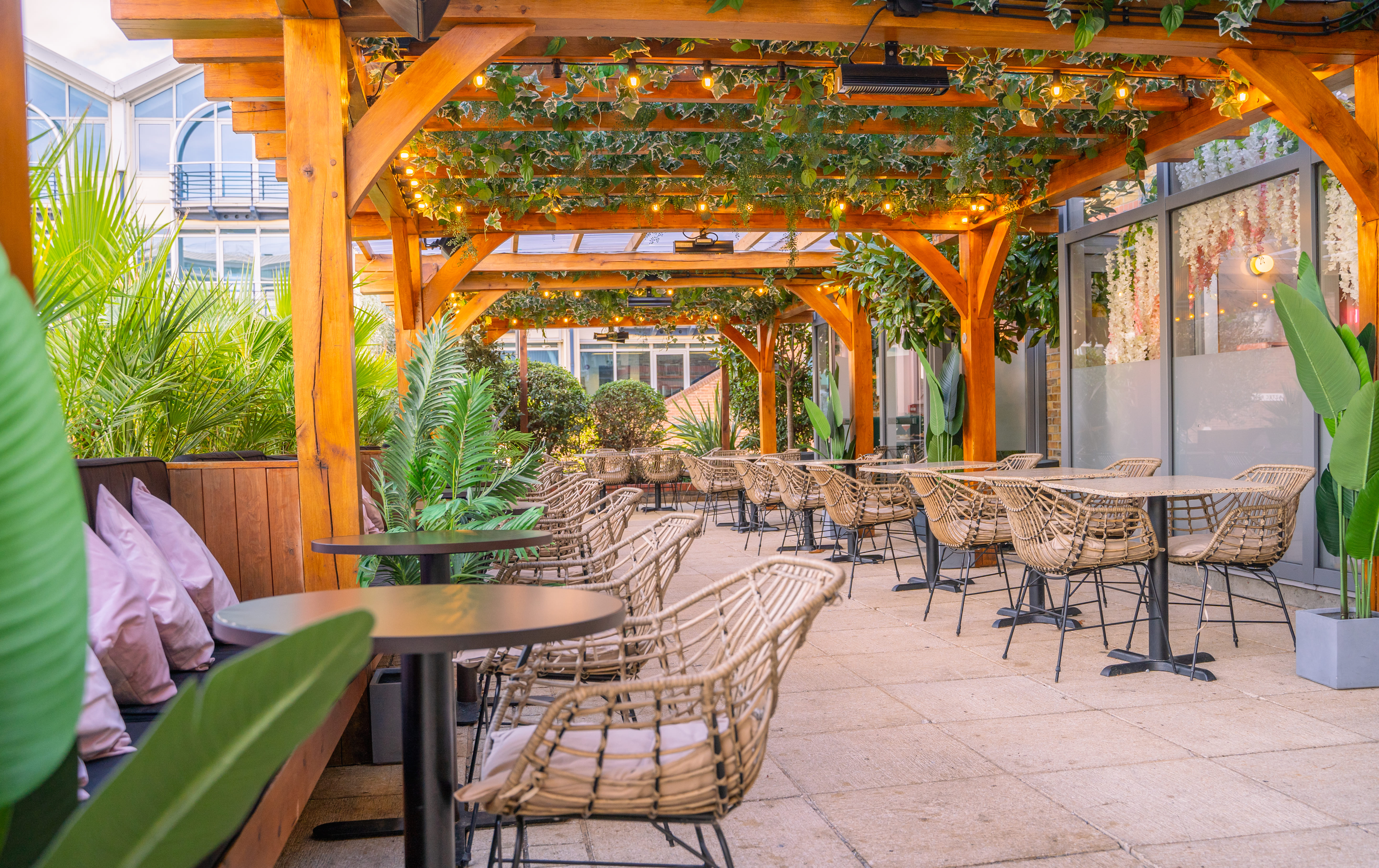 Outdoor event space with wooden pergolas, ideal for networking and gatherings.