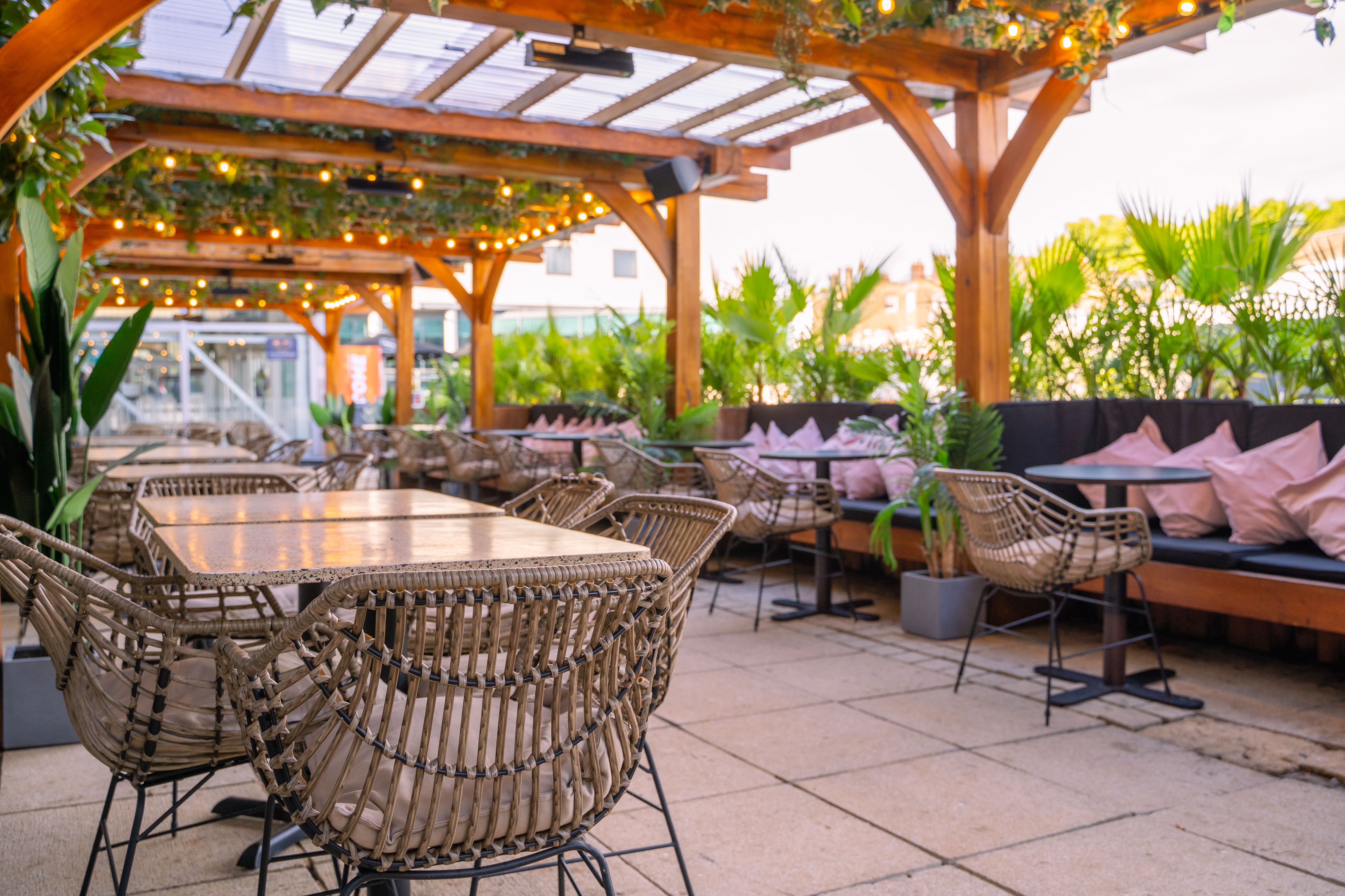 Outdoor event space at The Skinny Kitchen with stylish seating and lush greenery.