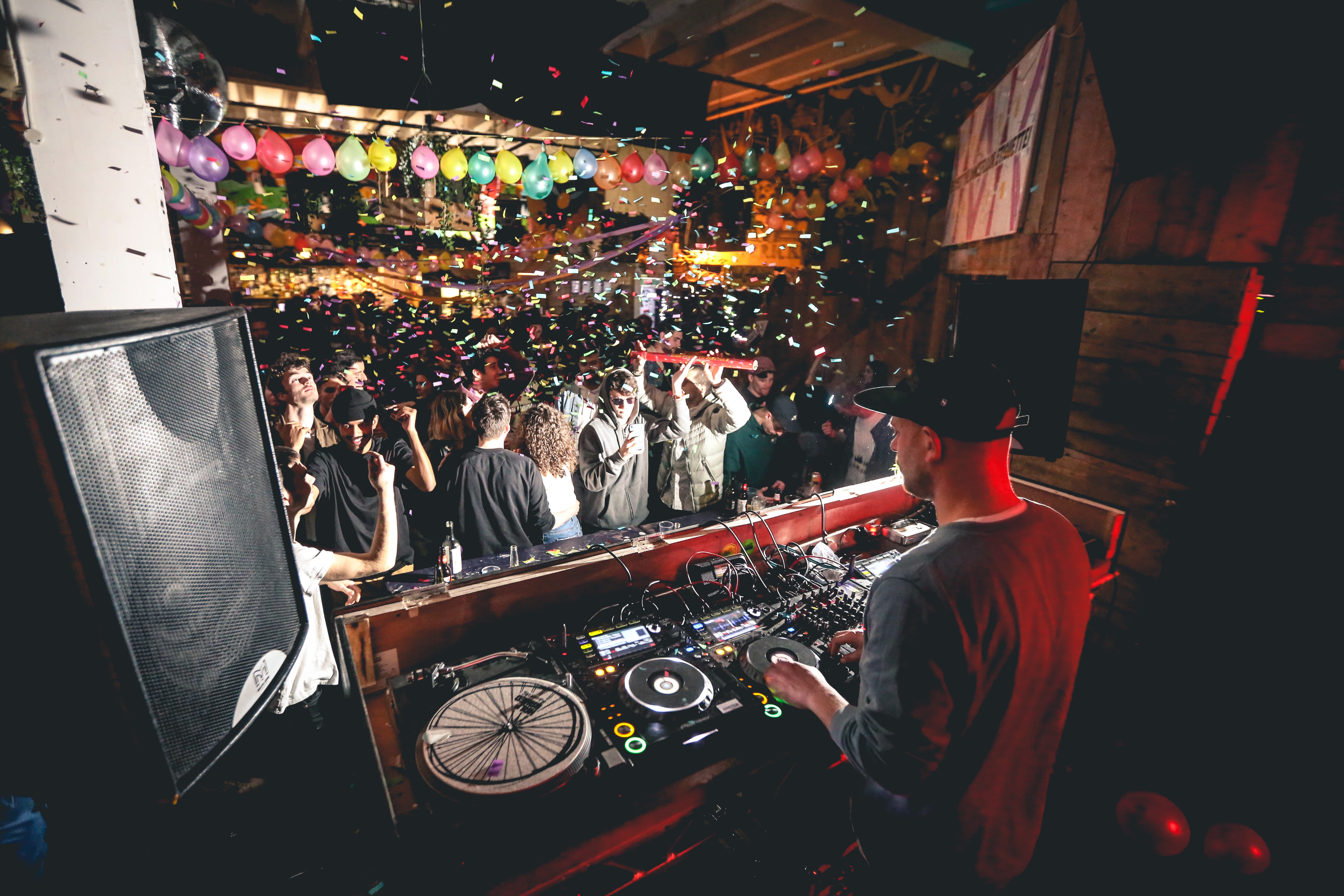 DJ at 90 Bar & Kitchen with colorful balloons for vibrant party atmosphere.