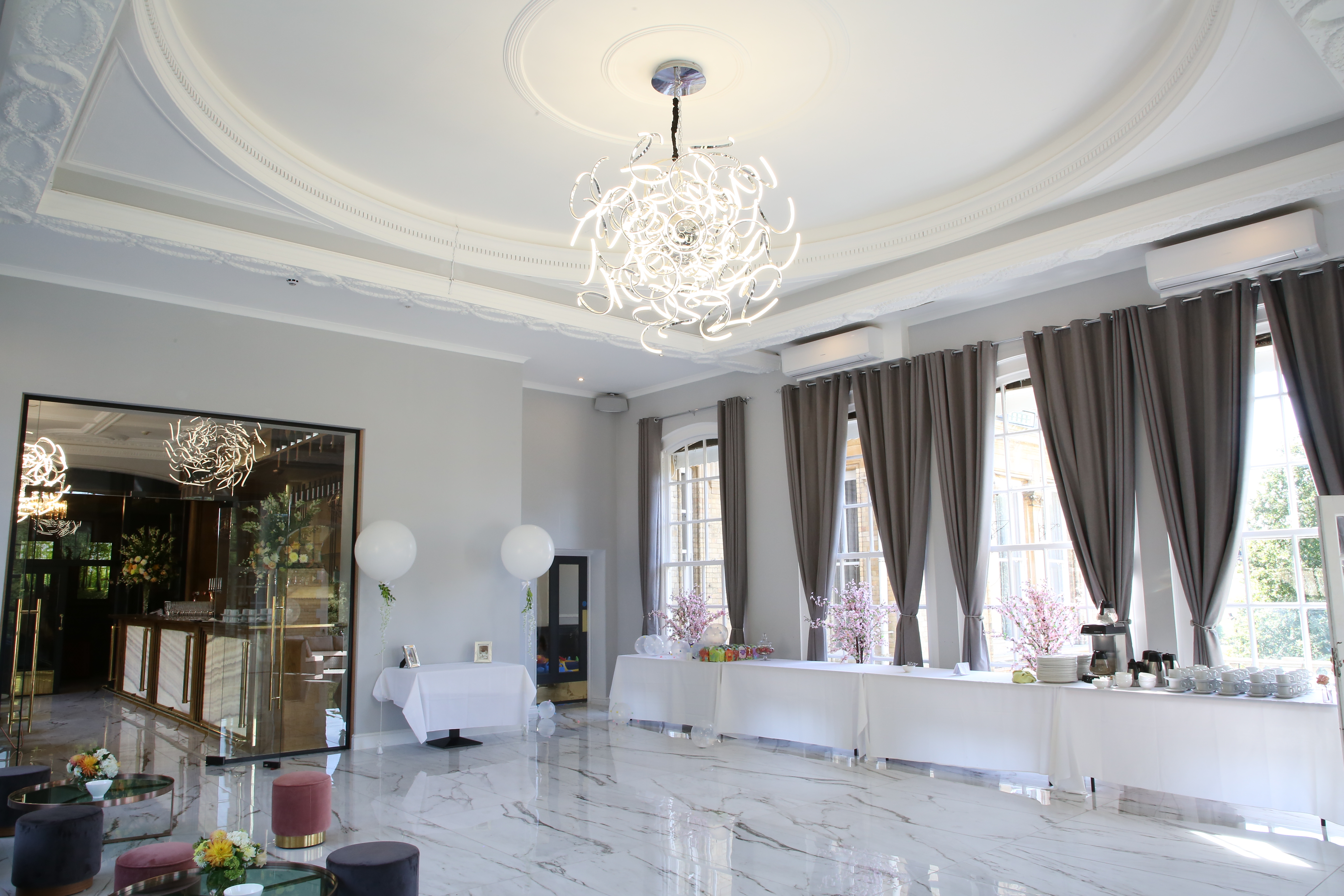 Hilltop Lounge at Ponsbourne Park Hotel, elegant event space with chandelier and natural light.