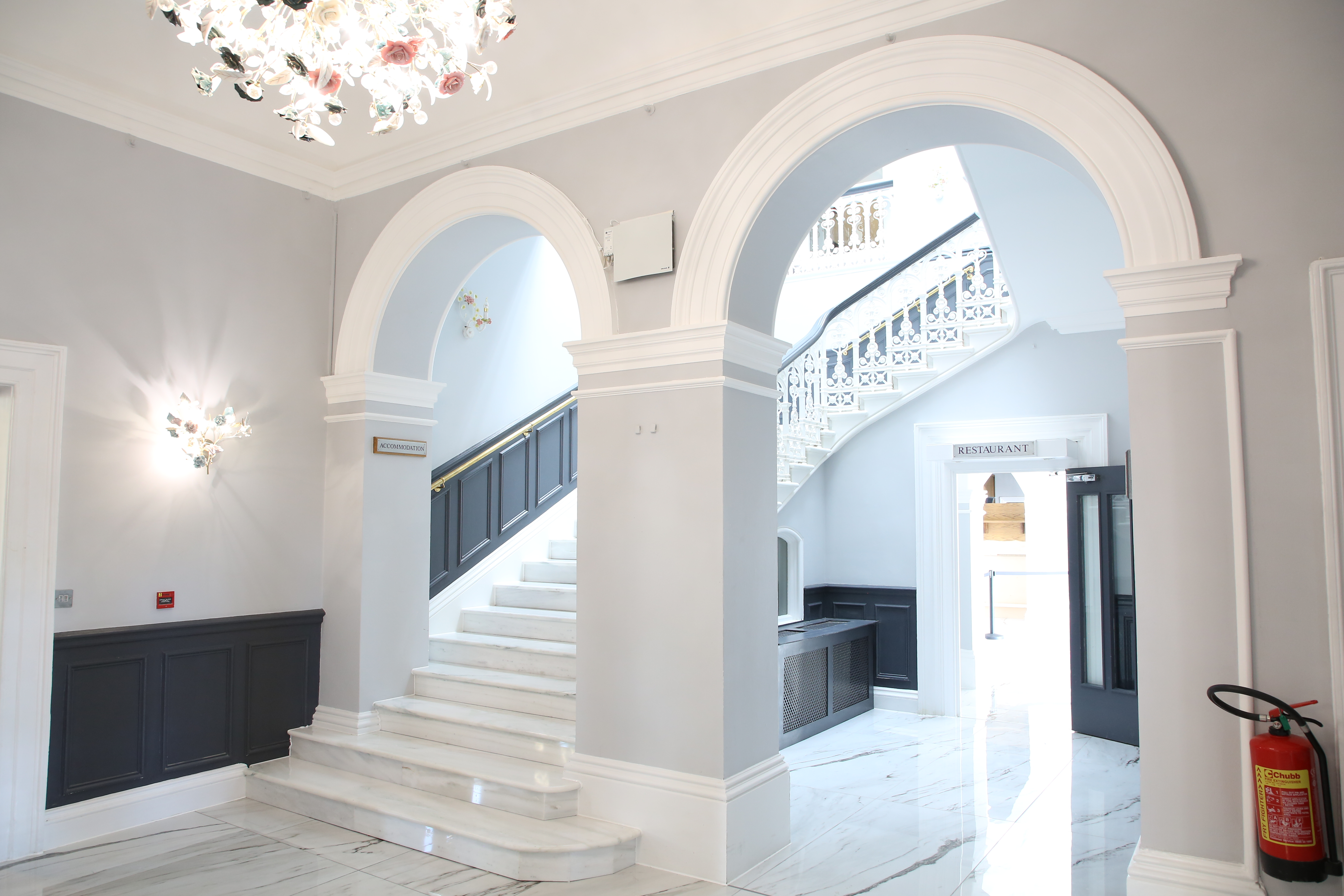 Hilltop Lounge entryway with grand staircase, ideal for elegant receptions and networking events.