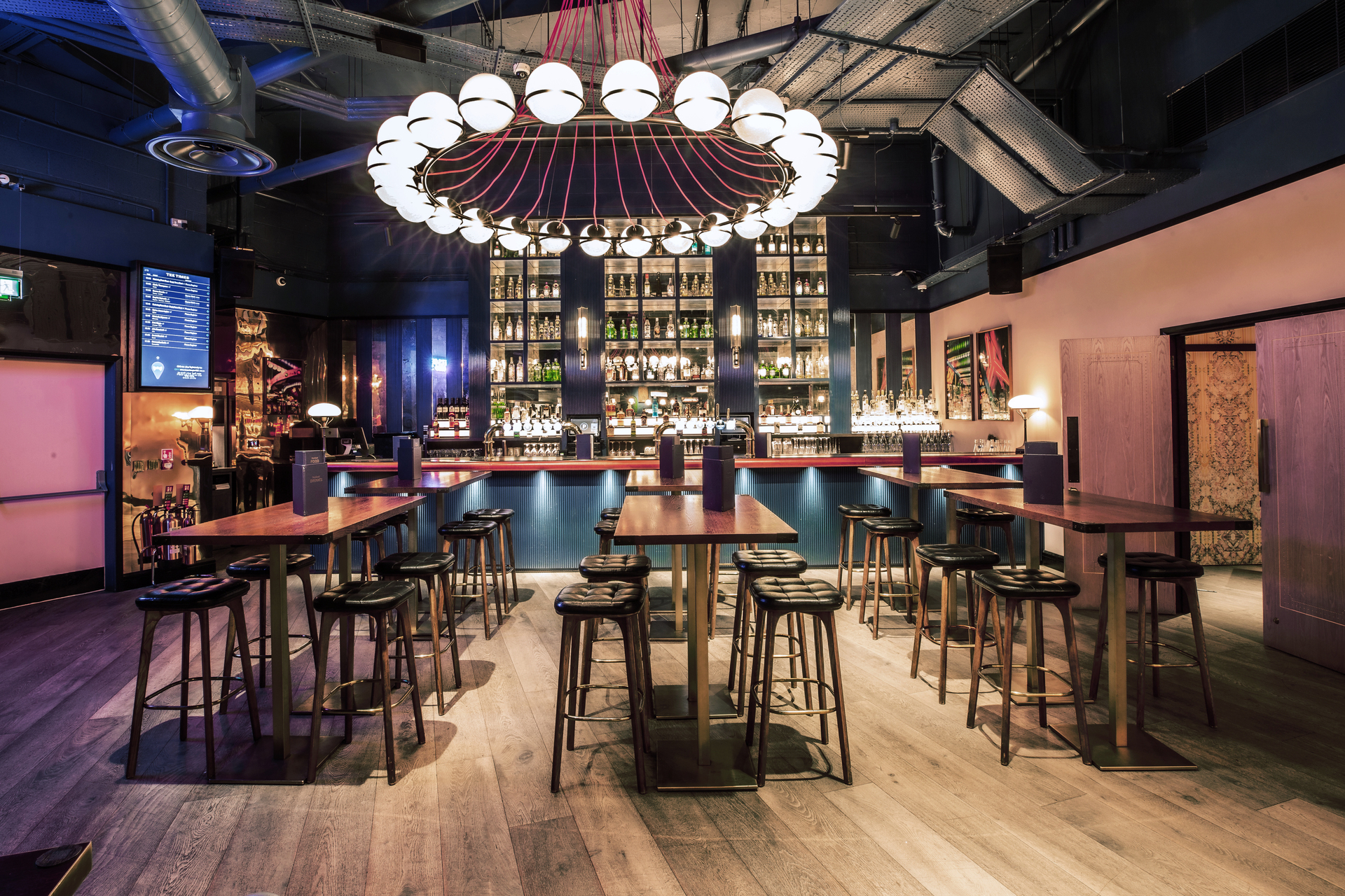Stylish bar area with chandelier at Puttshack Bank for cocktail receptions and gatherings.