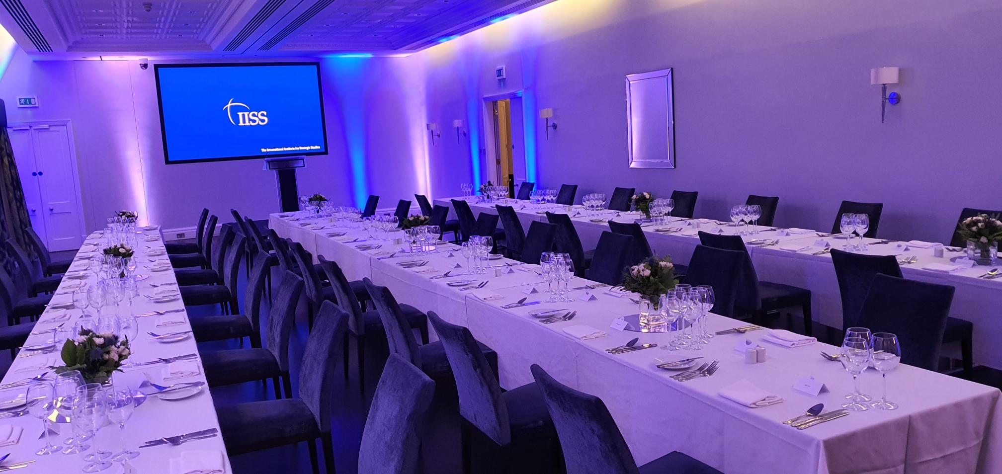 Lee Kuan Yew Room set for formal corporate event with elegant tables and blue lighting.