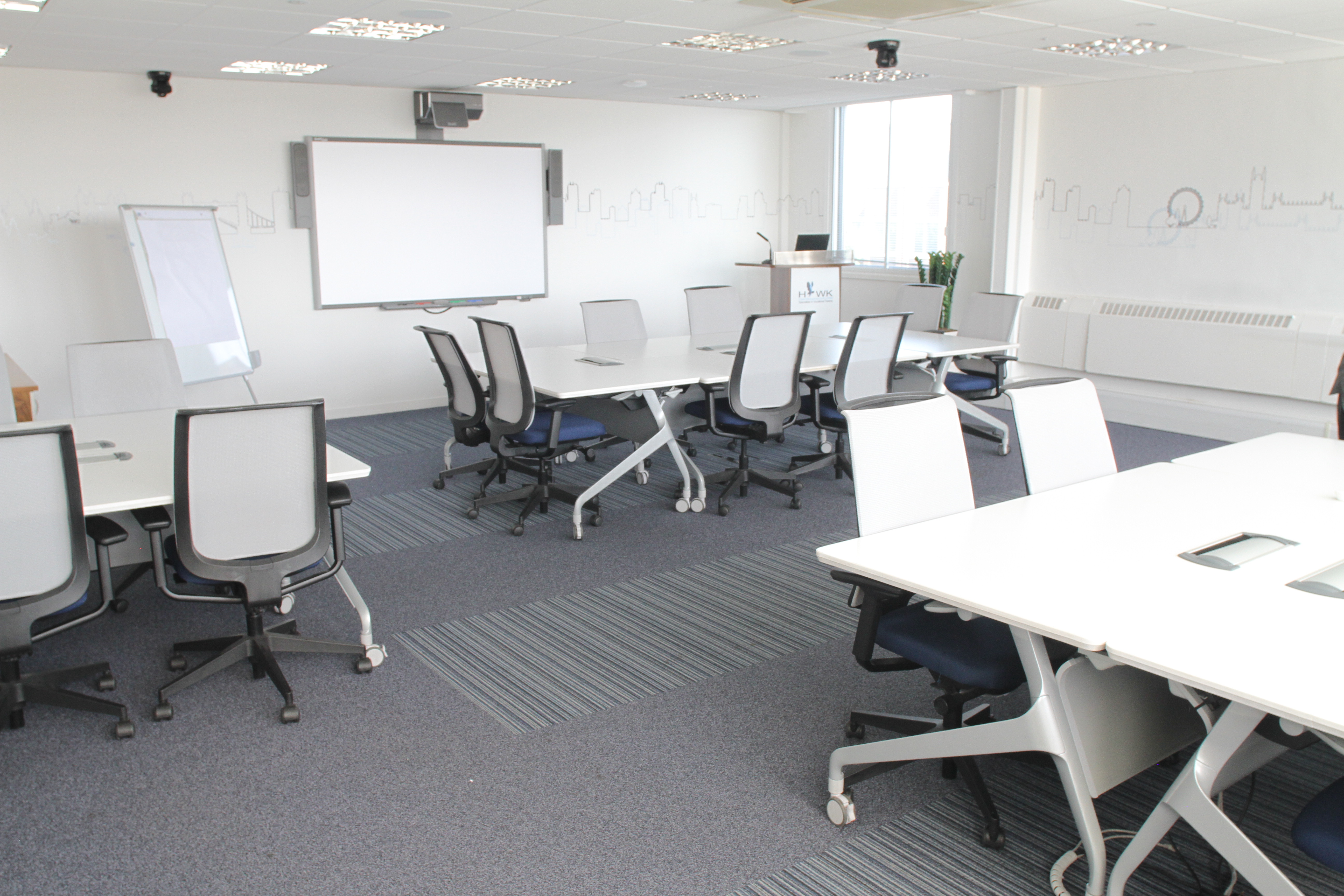 Versatile meeting space with modern furniture for workshops and presentations in Hawk Studios.