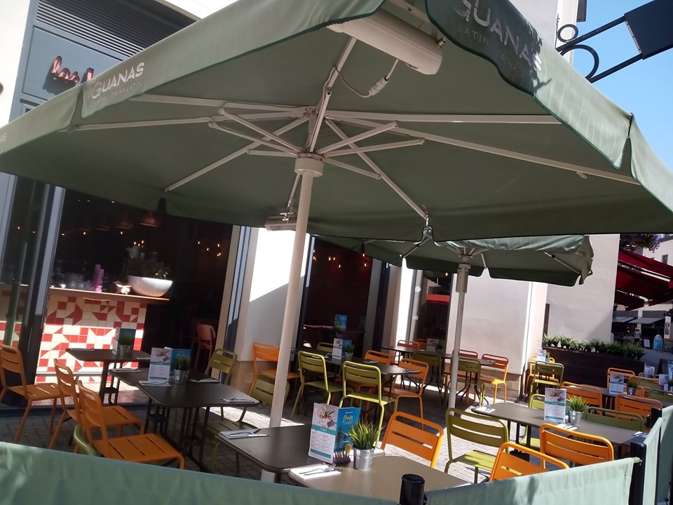 Outdoor dining area with green umbrellas at Las Iguanas, perfect for networking events.