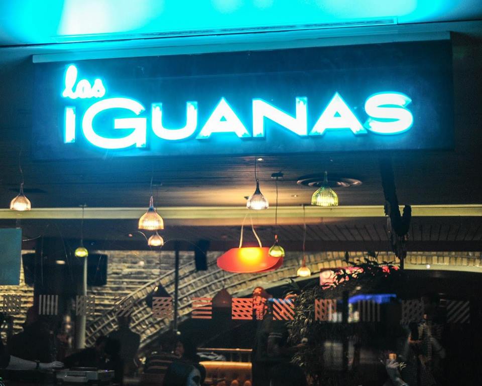 Vibrant Las Iguanas venue in London with neon signage for social events and gatherings.