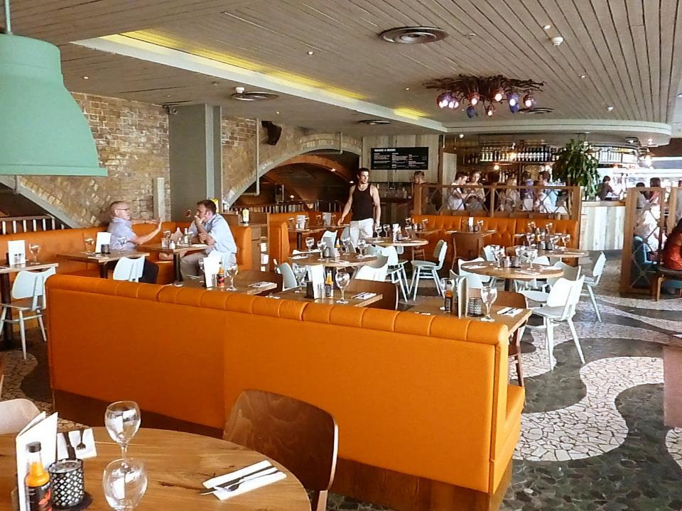 Vibrant Las Iguanas venue in London with orange seating for networking events.