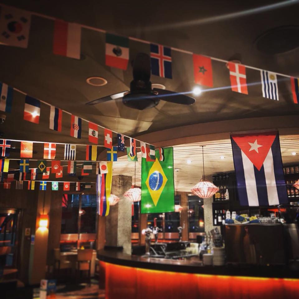 Vibrant multicultural event space with flags at Las Iguanas London O2 for networking celebrations.