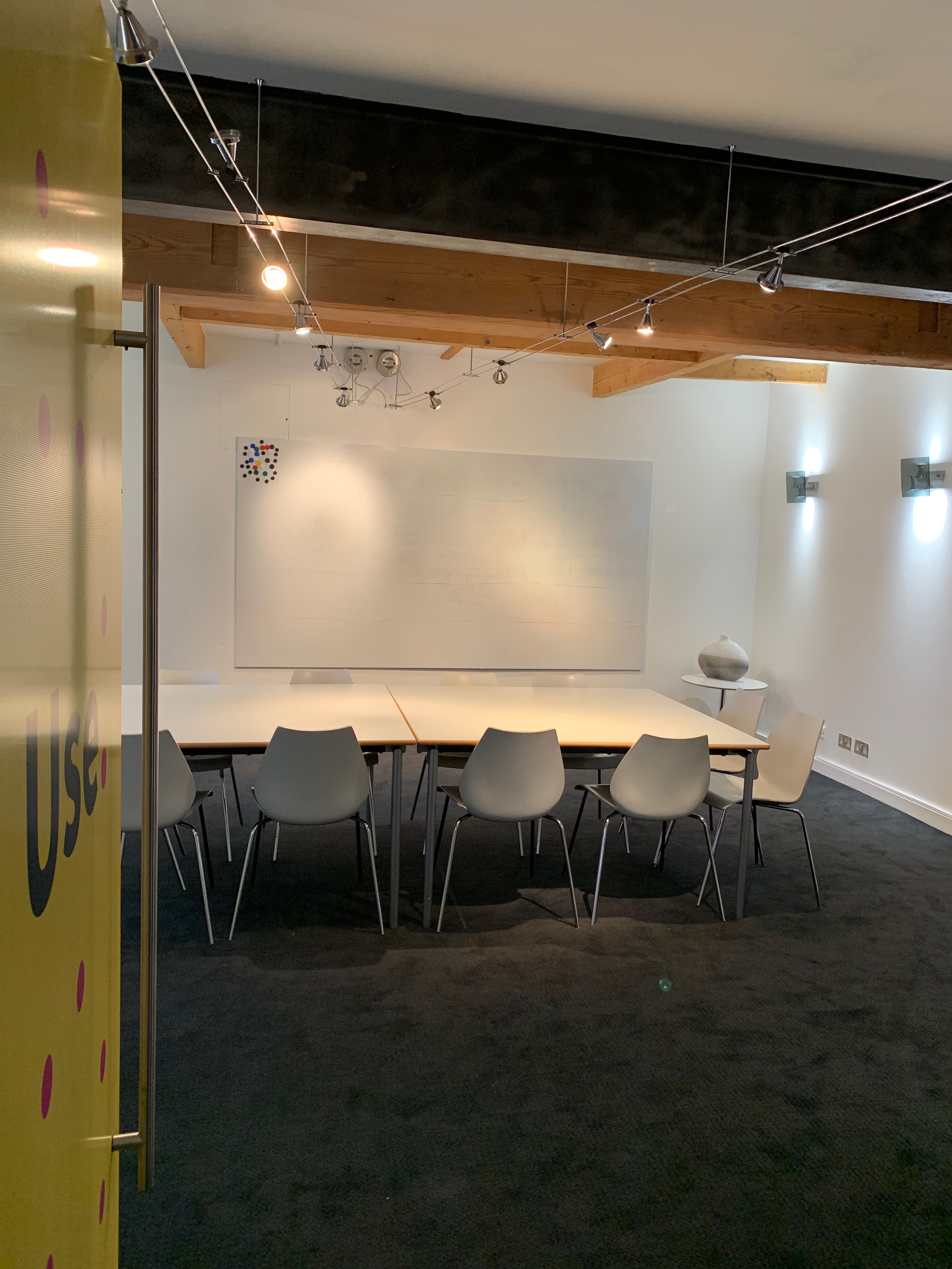 Modern meeting room with spacious whiteboard for collaborative workshops and discussions.