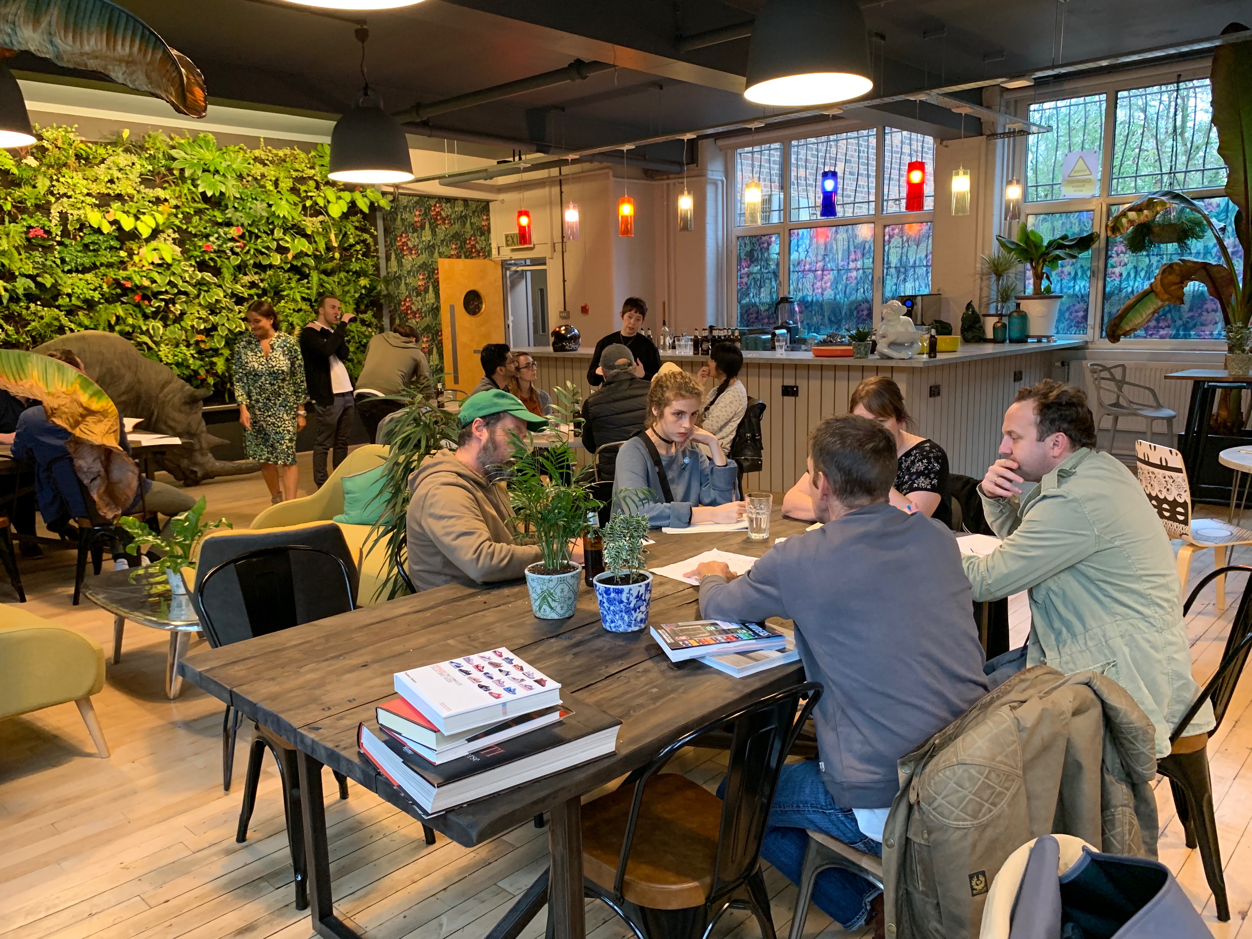 Vibrant Use.Cafe meeting space with greenery, ideal for workshops and collaboration.