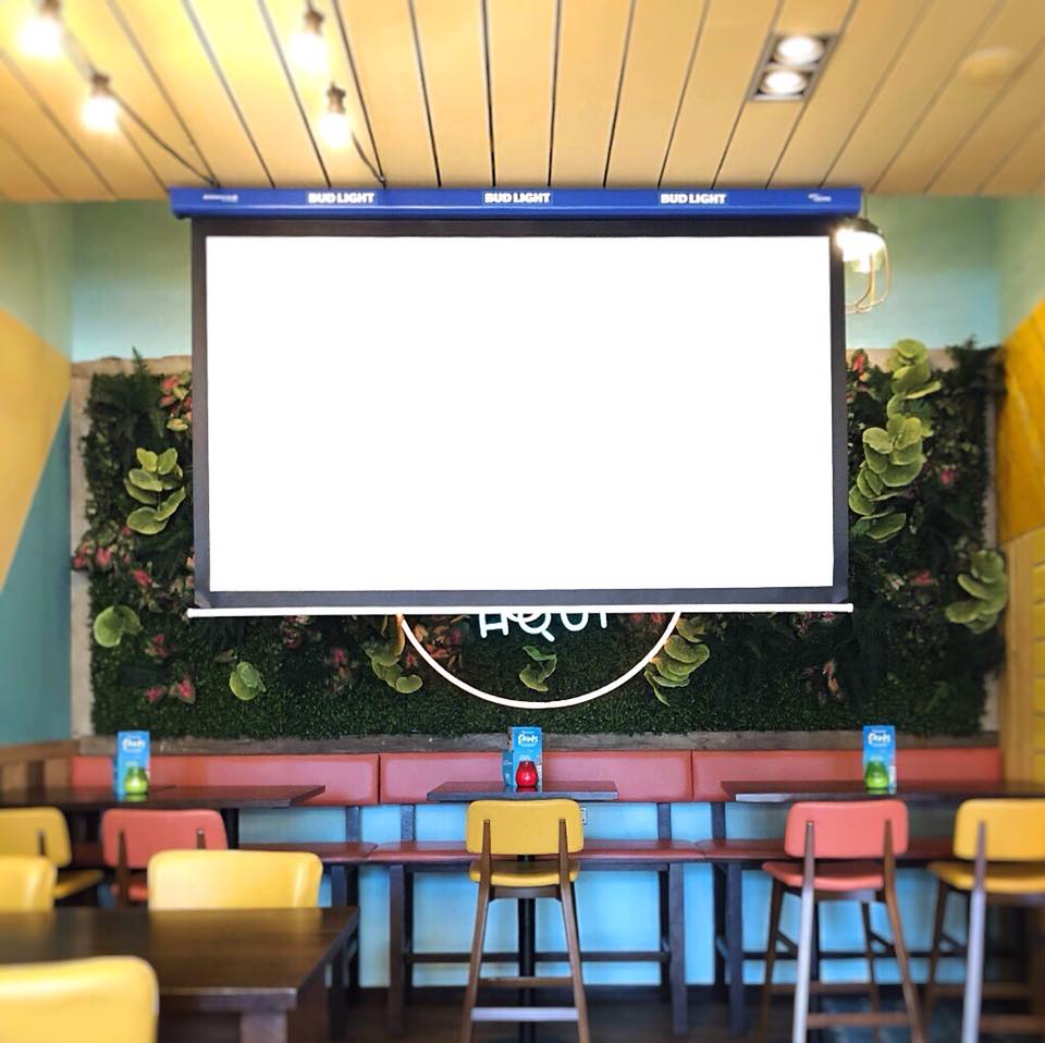 Vibrant meeting space in Las Iguanas Portsmouth with large screen for presentations.