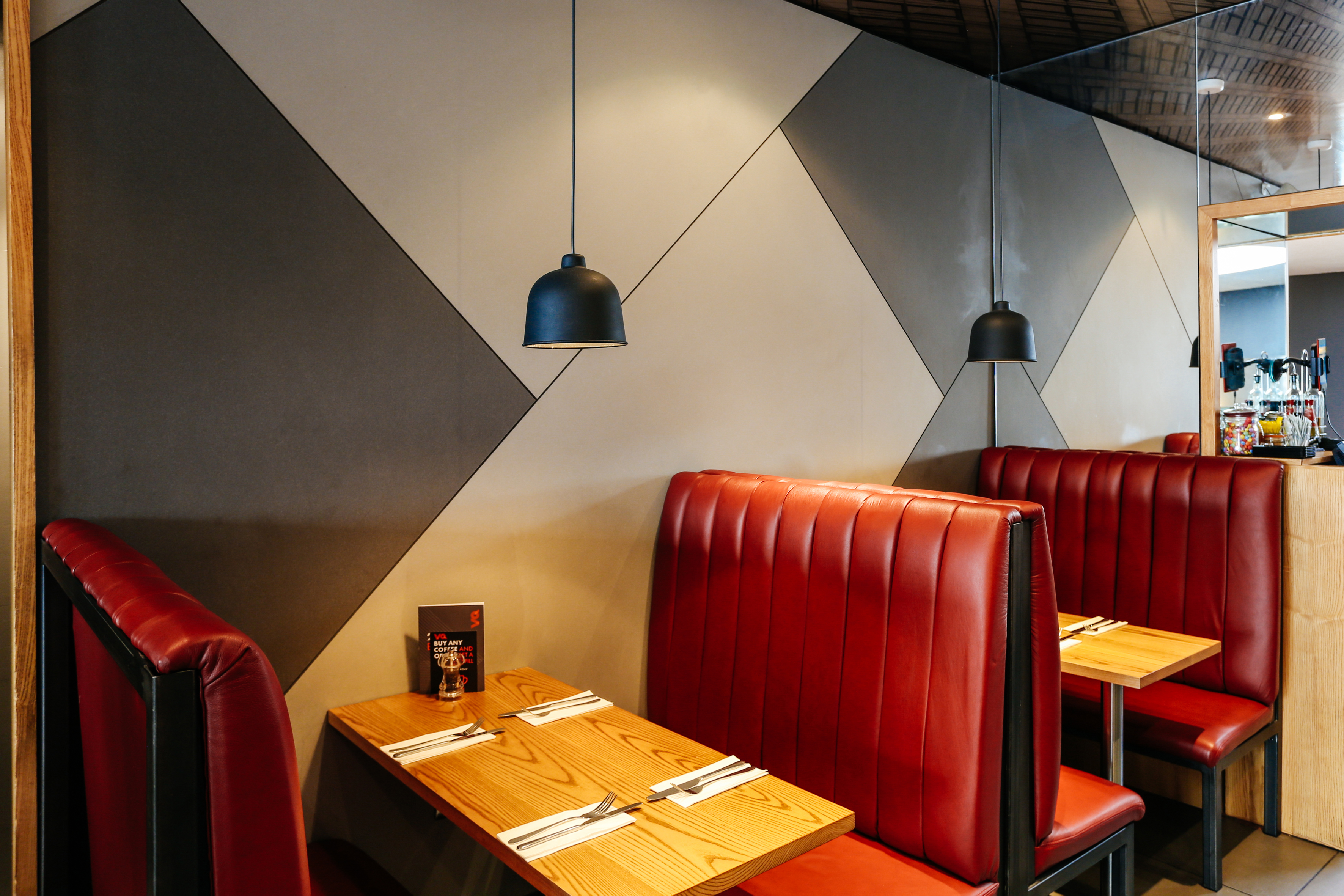 Modern restaurant interior with cozy red booths, ideal for networking events and dining.