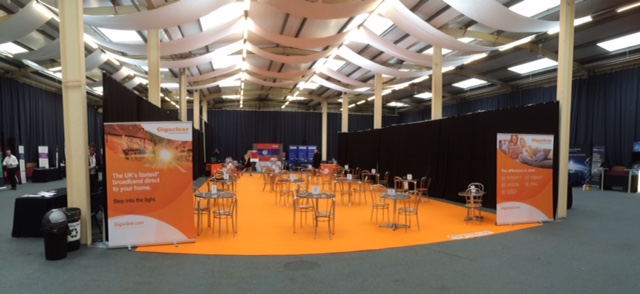 Cotswold Hall event space with orange carpet, ideal for networking and presentations.