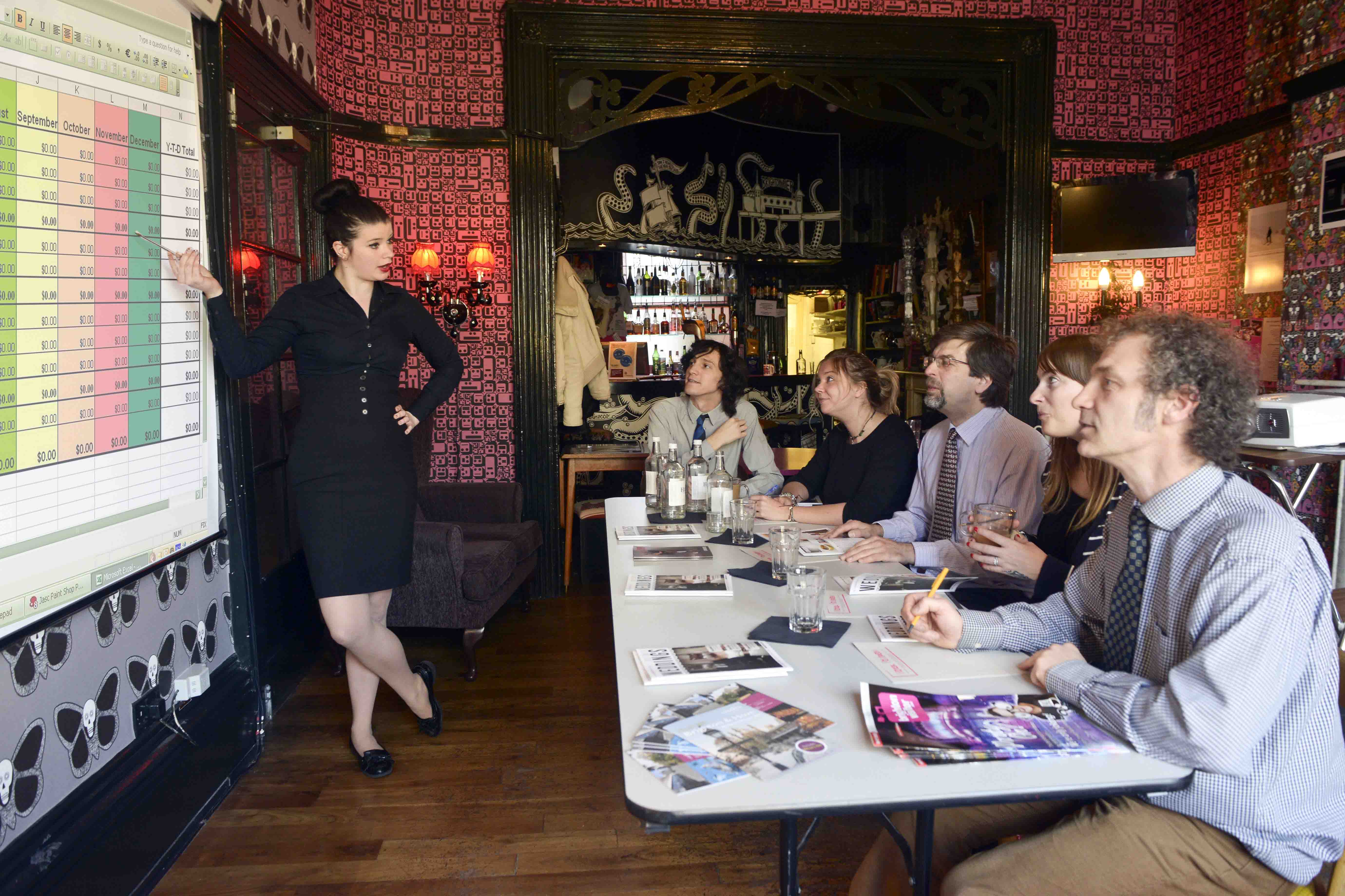 "Stylish hotel meeting room with presenter and engaged audience for creative collaboration."