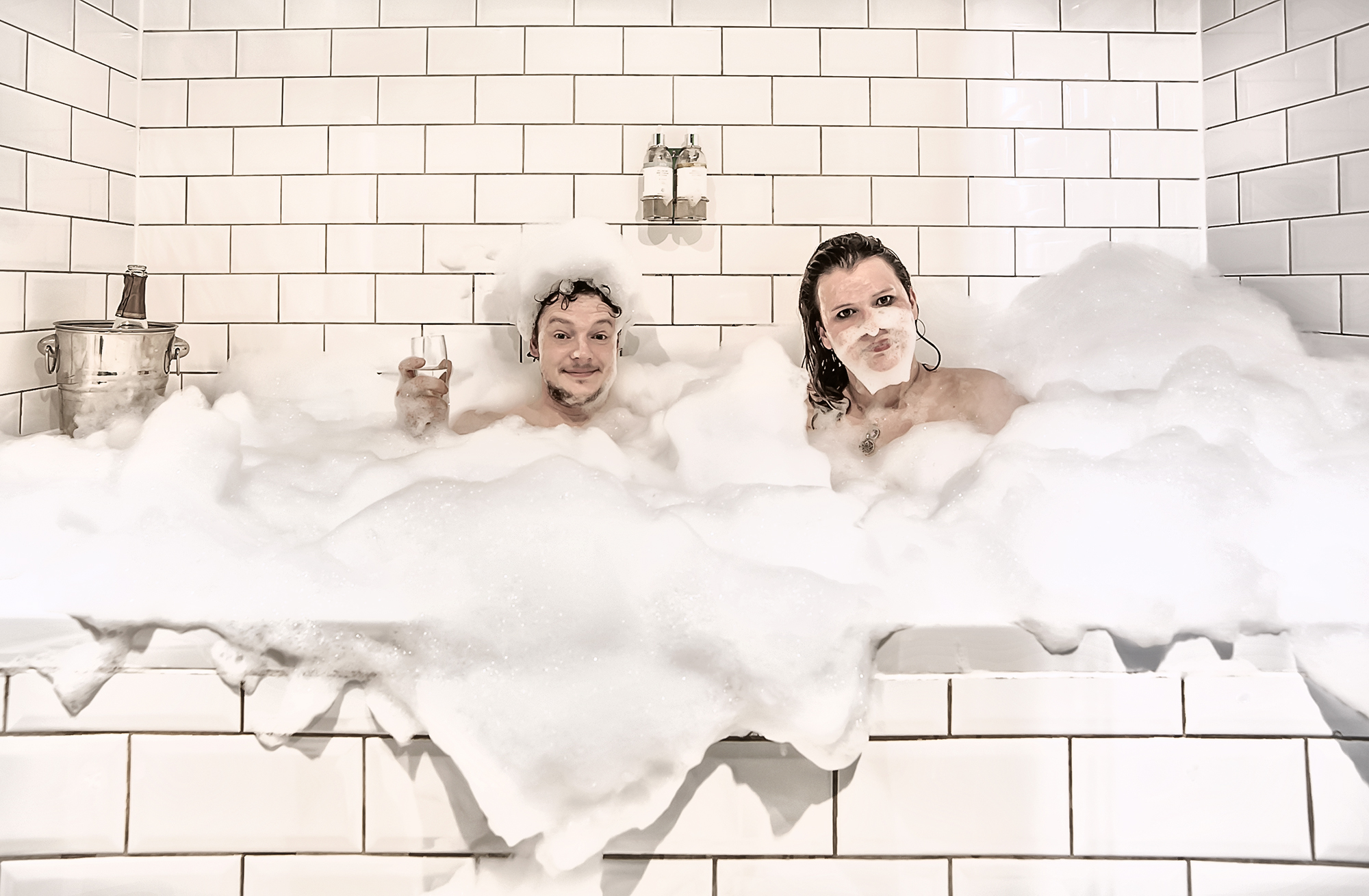 "Playful moment in luxurious bubble bath at Hotel Pelirocco for corporate retreats."