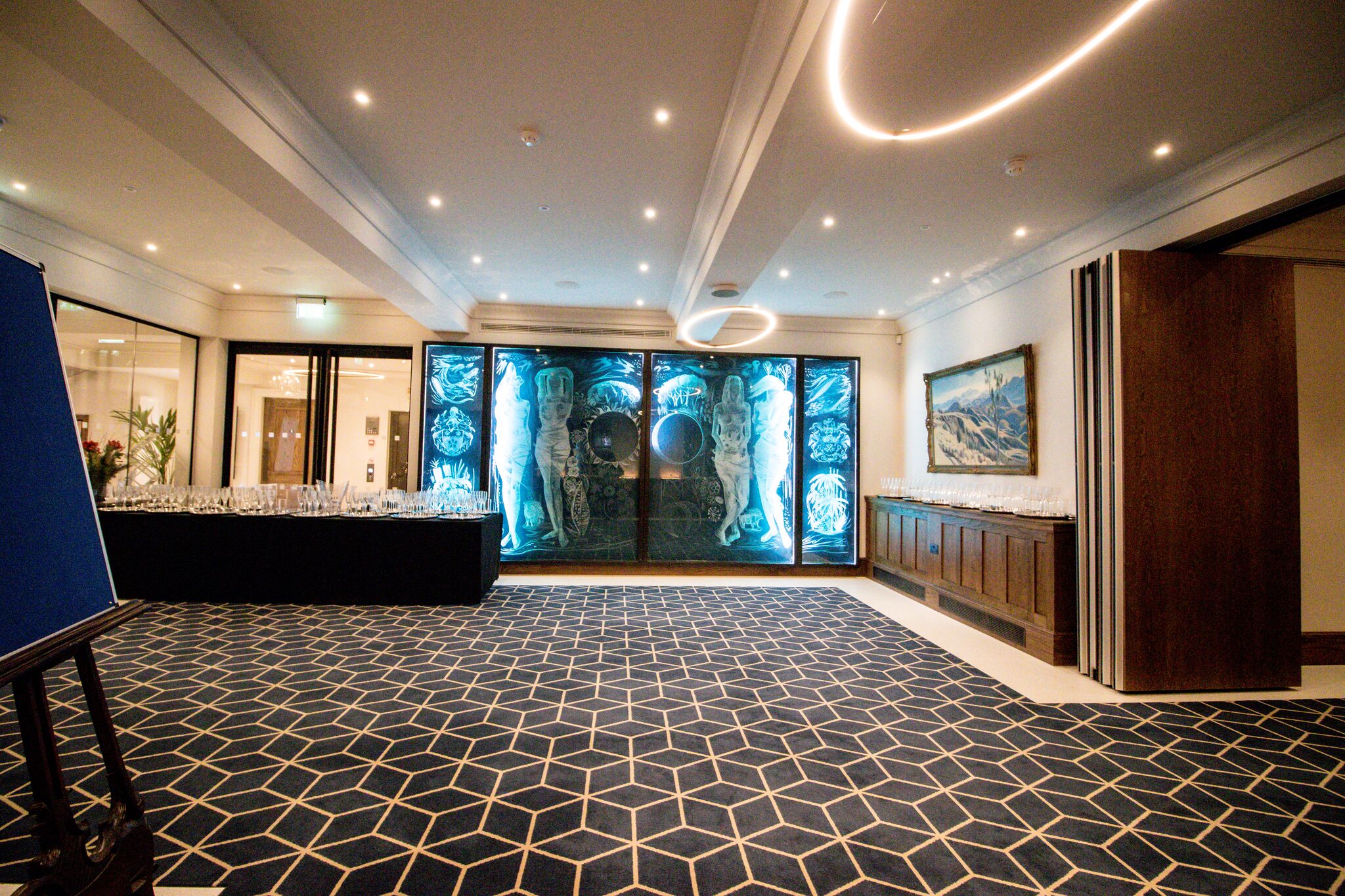Sophisticated event space with blue backlit display at 87 Barts Close for corporate functions.