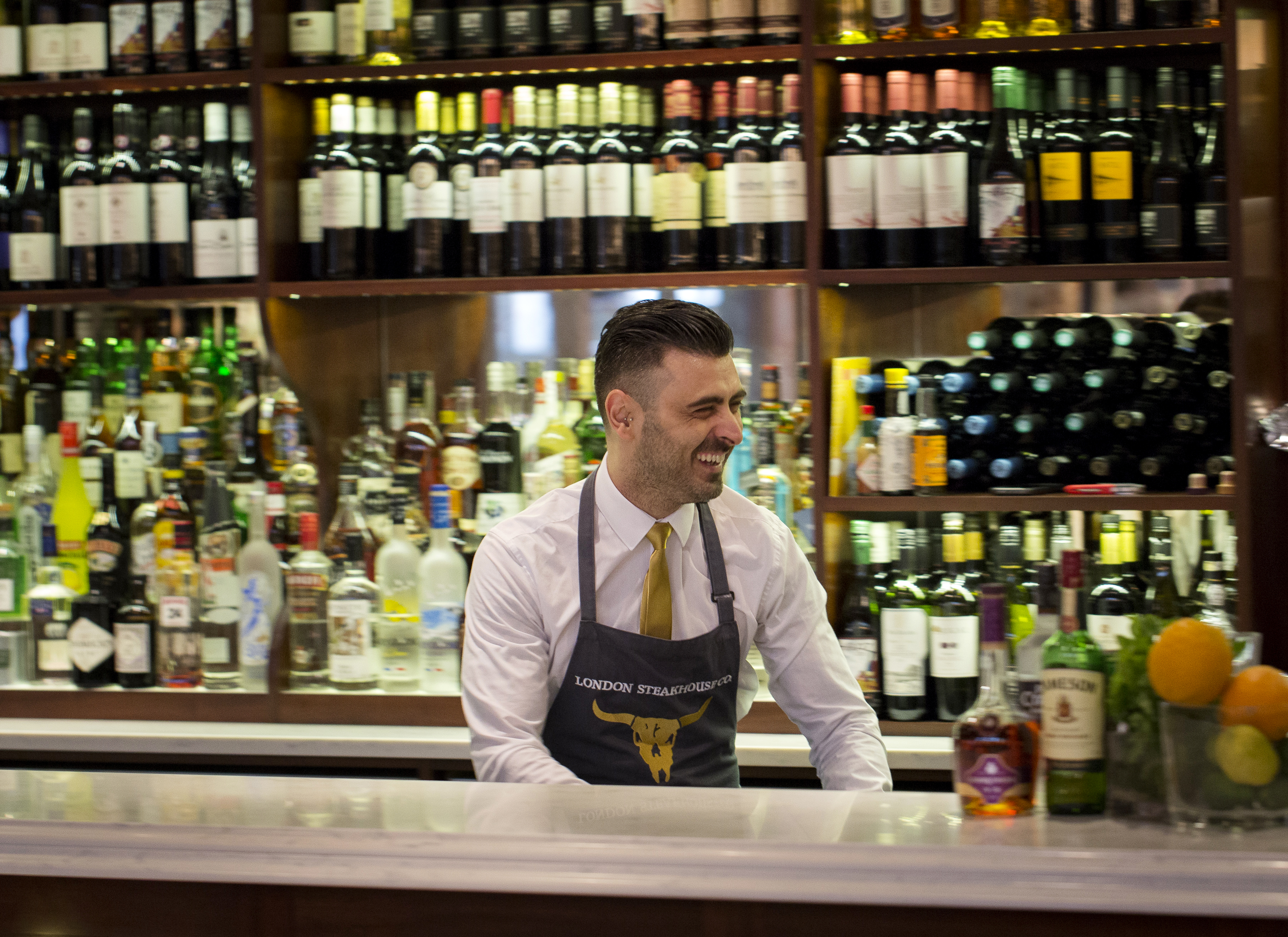 Bartender in stylish bar at London Steakhouse, perfect for events and gatherings.