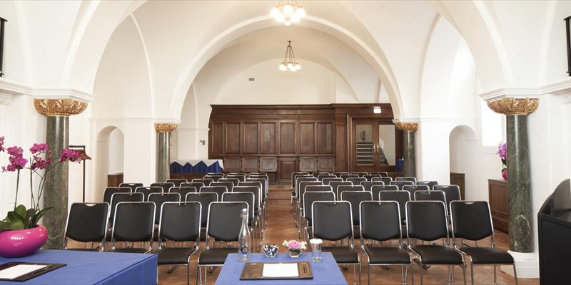 Chapel Suite meeting space with black chairs, ideal for presentations and workshops.