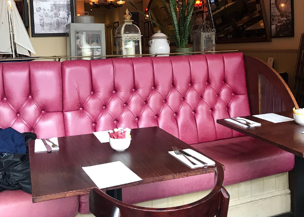 Cozy dining area with plush pink seating at Café Rouge London for intimate meetings.
