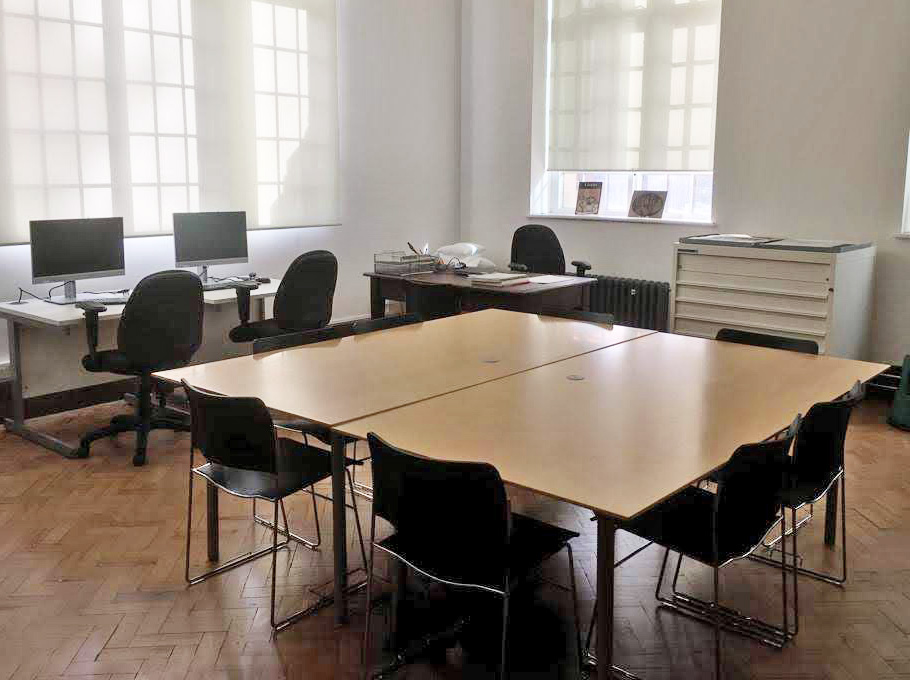 Library meeting space with large table, ideal for hybrid events and discussions.