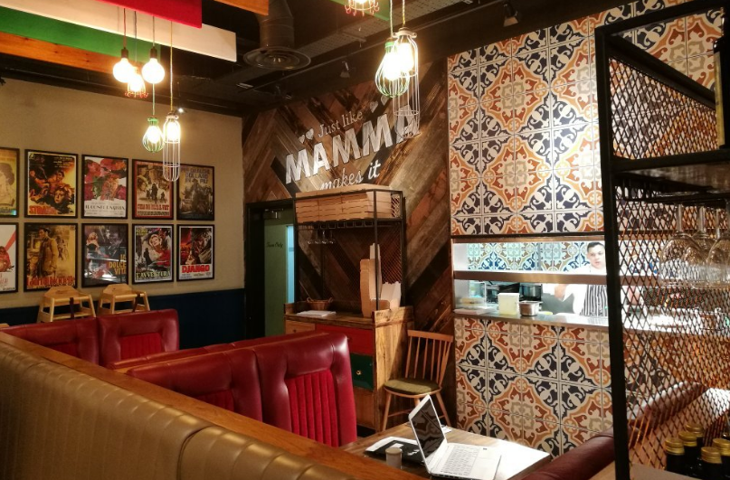 Vibrant Bella Italia venue with cozy booth seating for casual meetings and events.