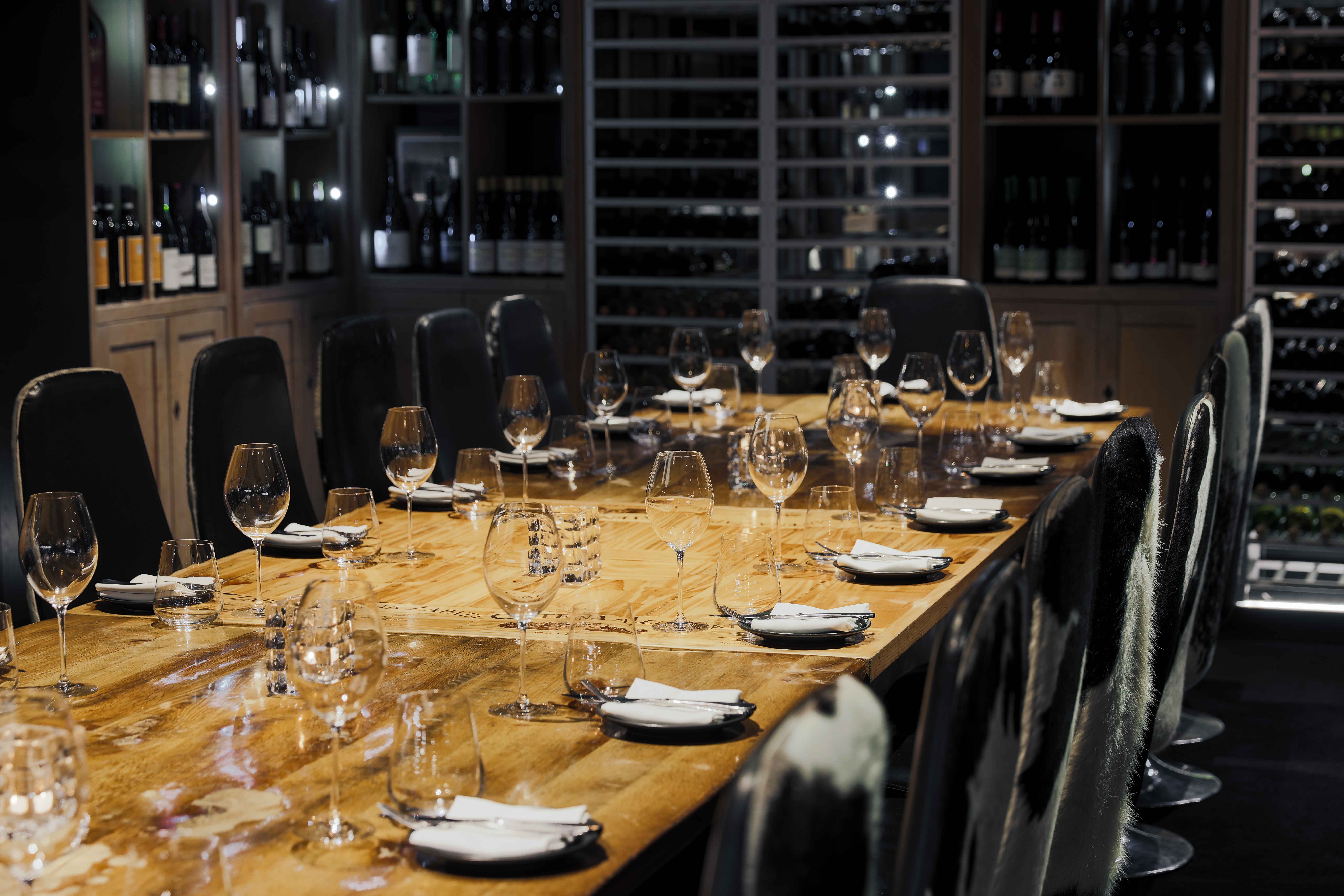 Elegant wine room with wooden table, ideal for corporate meetings and wine tastings.