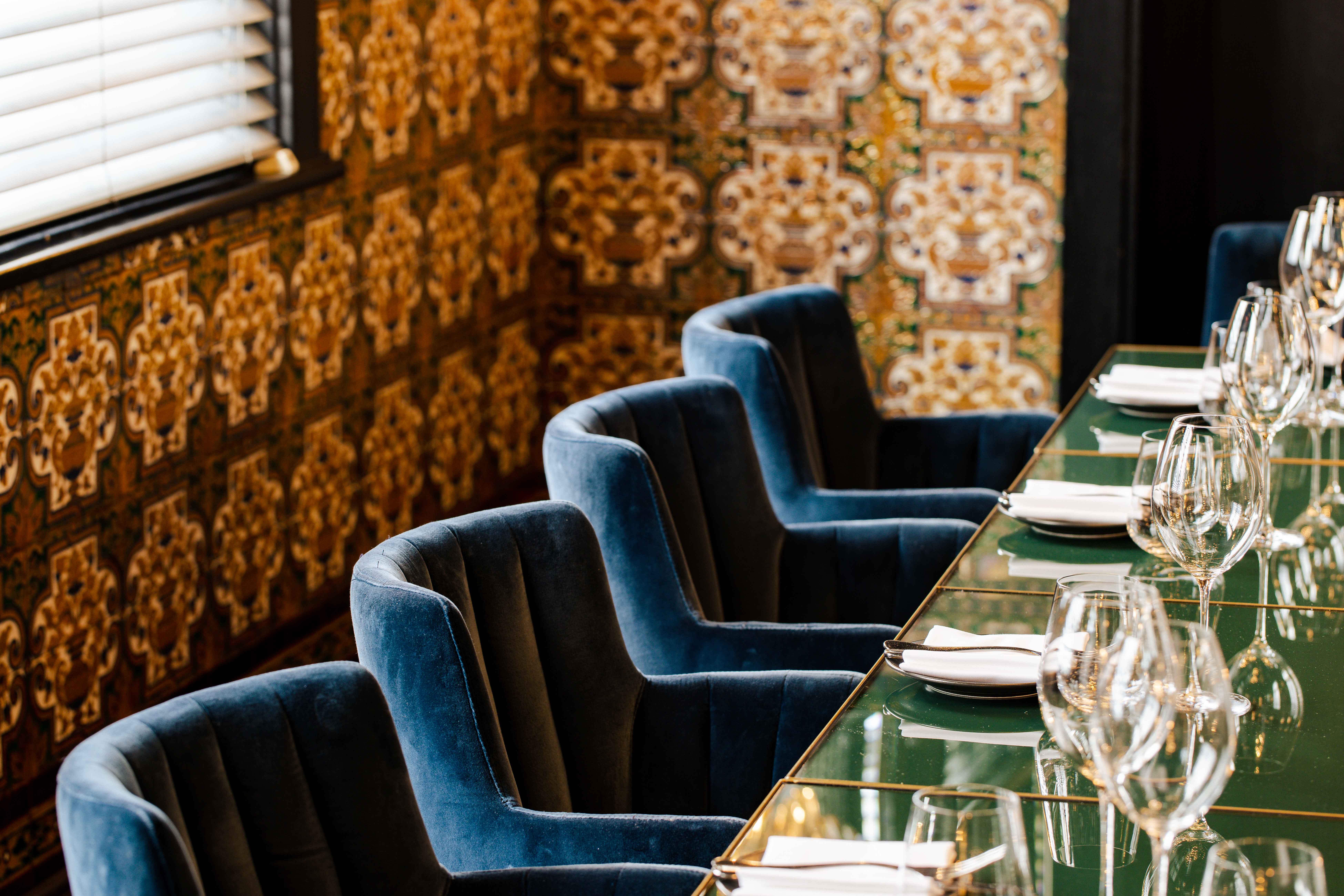 Sophisticated Spanish Room dining setup with plush blue chairs for upscale events.