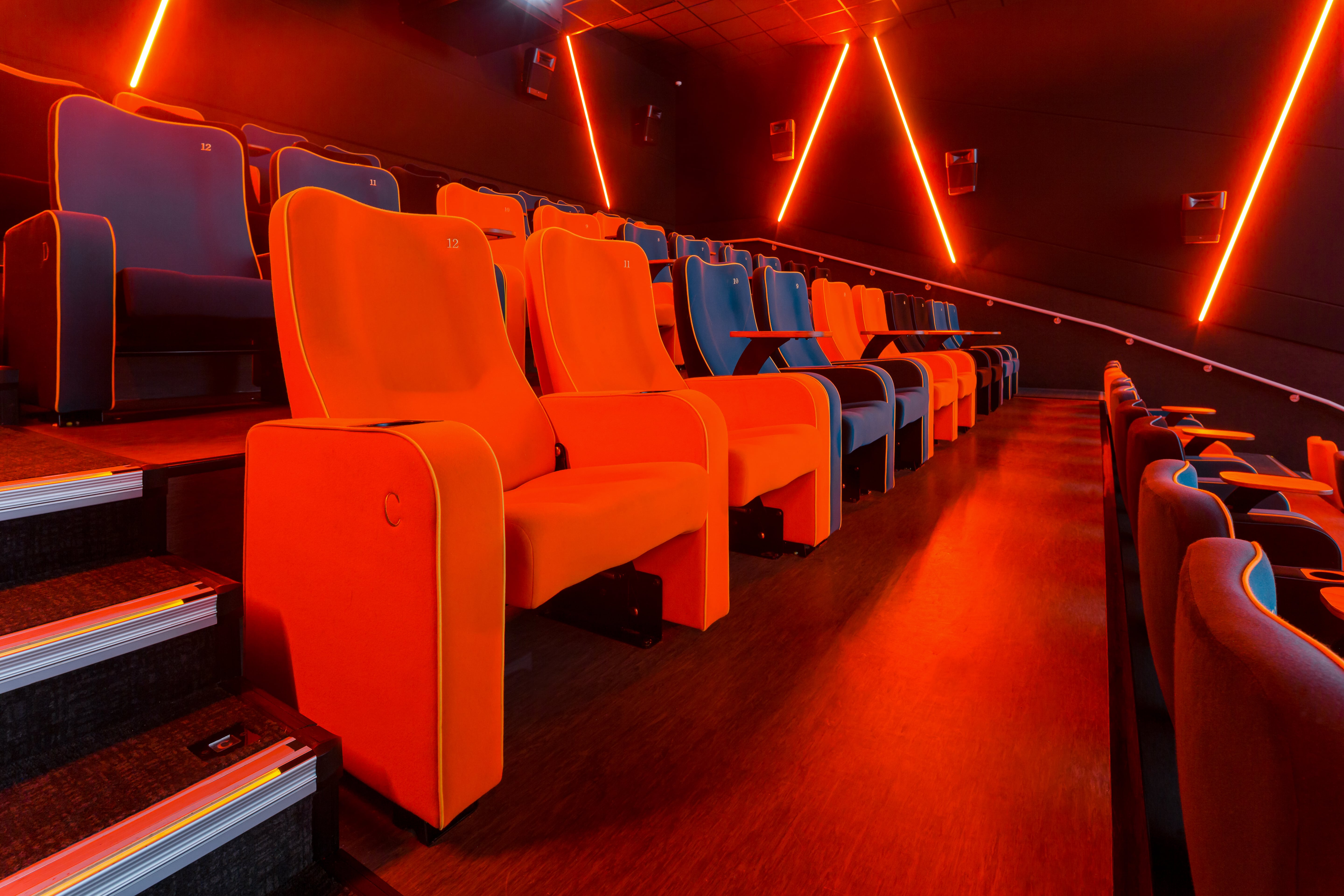 Modern cinema auditorium with orange and blue seating, ideal for screenings and presentations.