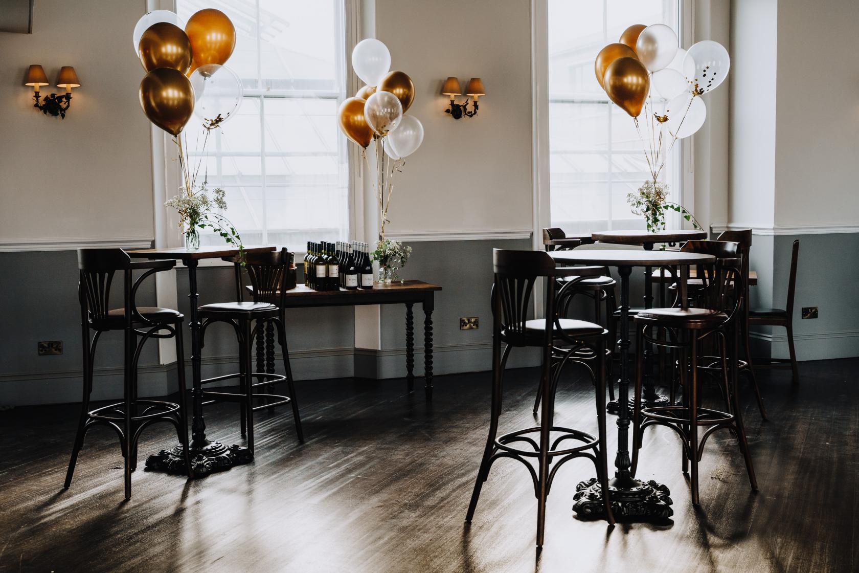 Elegant event space at The Admiral Hardy with gold and white balloons for celebrations.