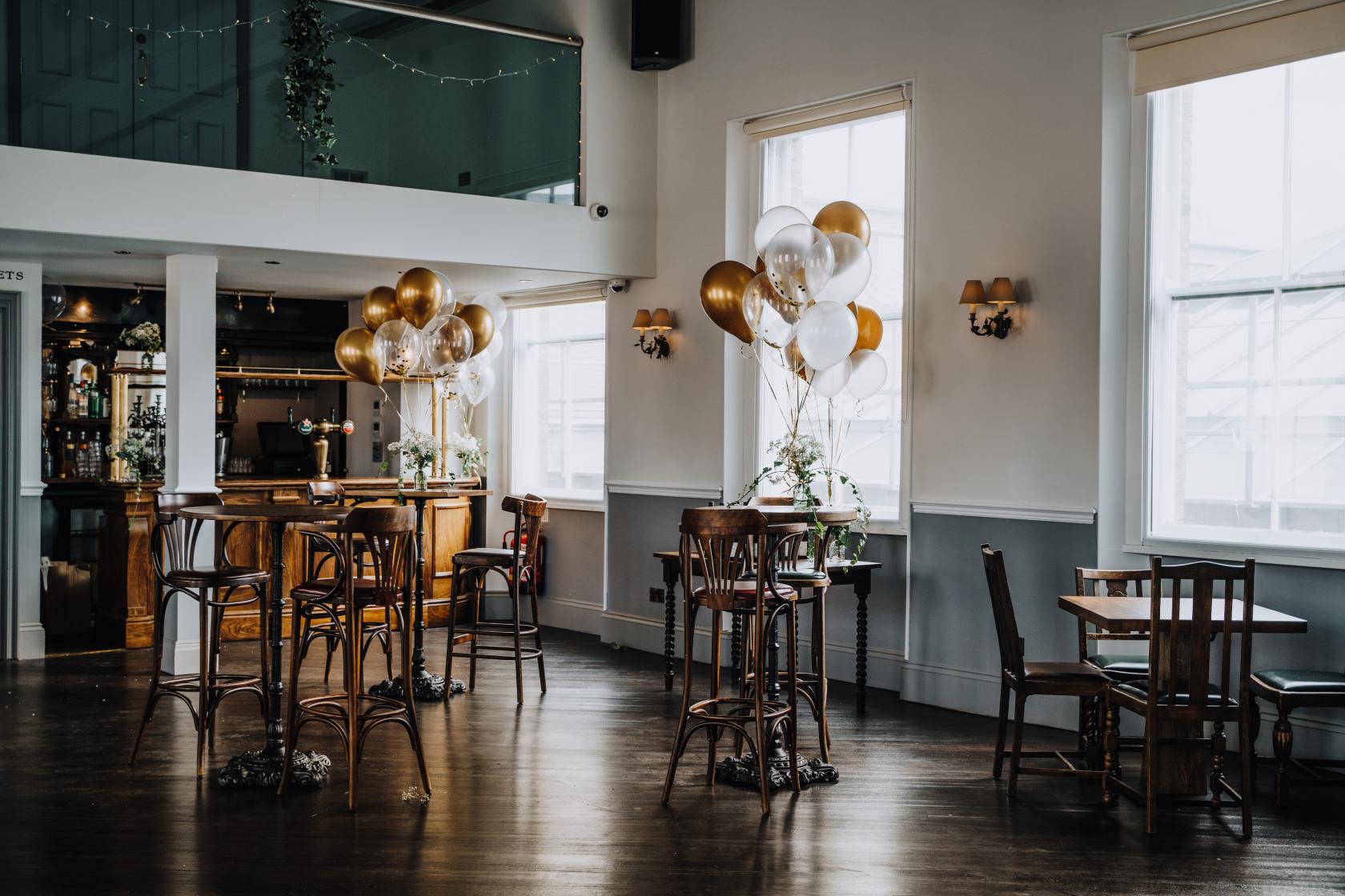 Elegant event space at The Admiral Hardy with gold and white balloons for gatherings.