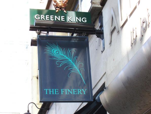 Stylish venue sign for The Finery with peacock feather design, ideal for elegant events.