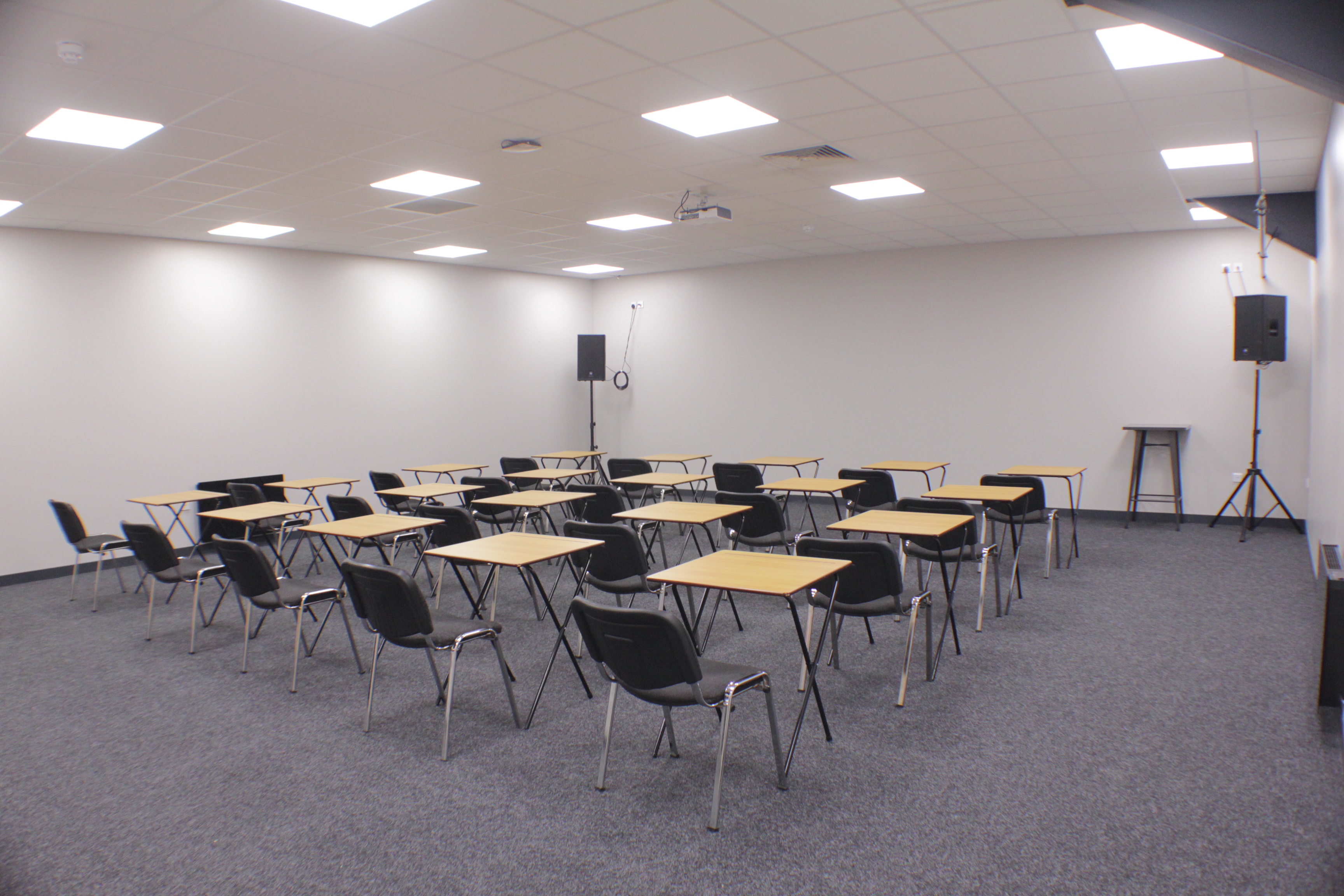 Versatile workshop space with audio equipment for seminars and meetings.