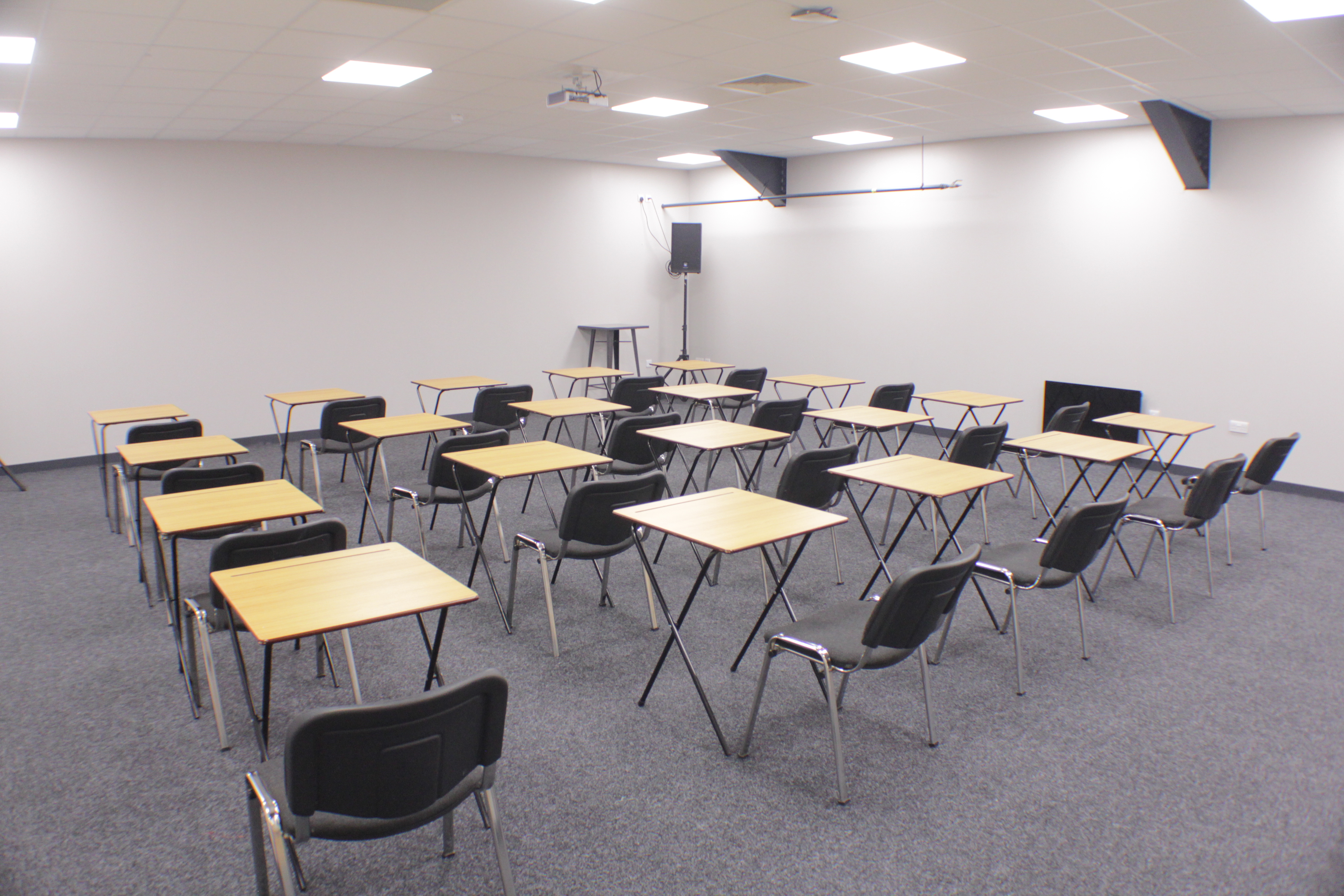 Versatile meeting space with tables and chairs for workshops or training sessions.