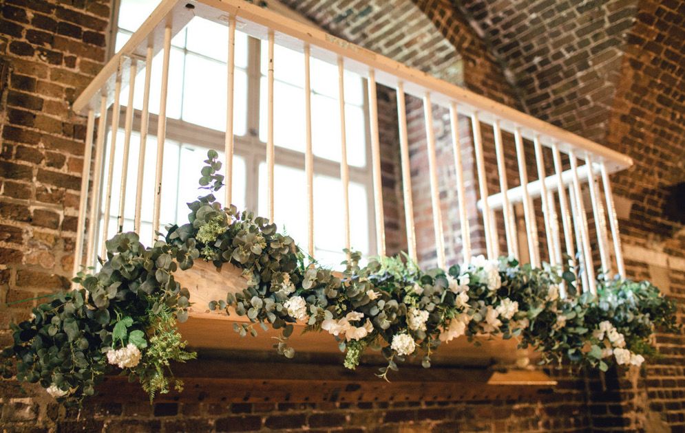 Lush balcony with white flowers at The Crypt, perfect for weddings and upscale events.
