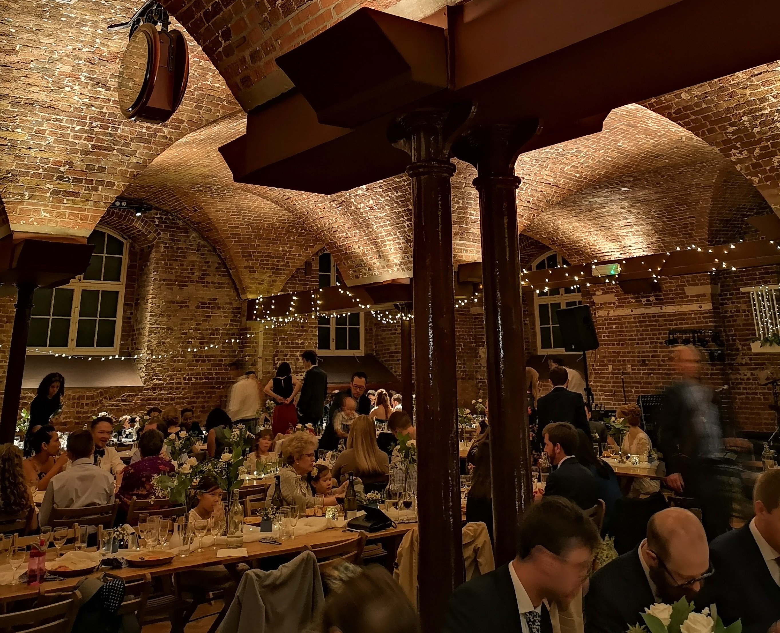 Elegant event space in The Crypt with string lights, perfect for networking and celebrations.