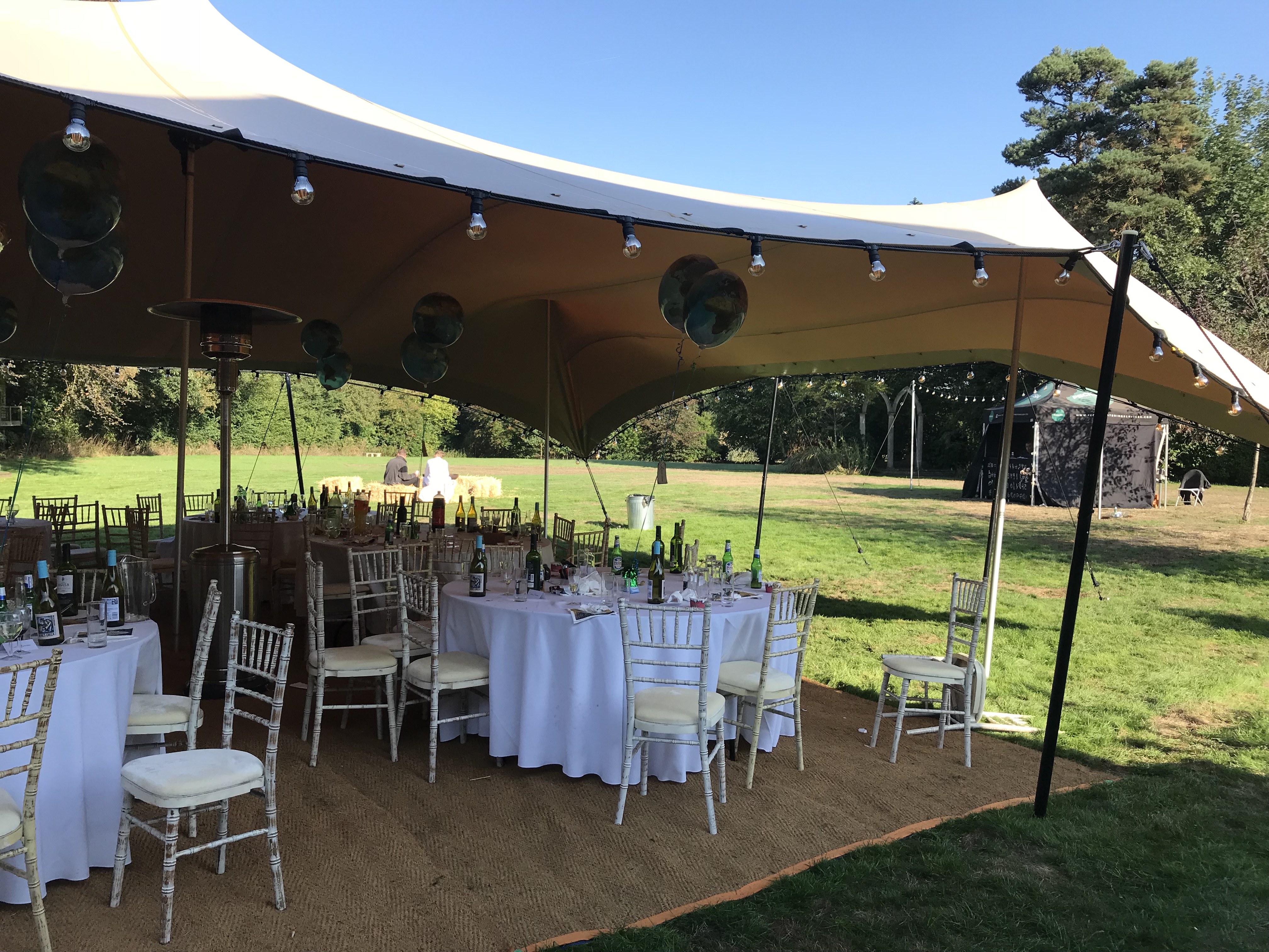 Elegant outdoor wedding setup in lush gardens at Foxlea Manor with charming string lights.