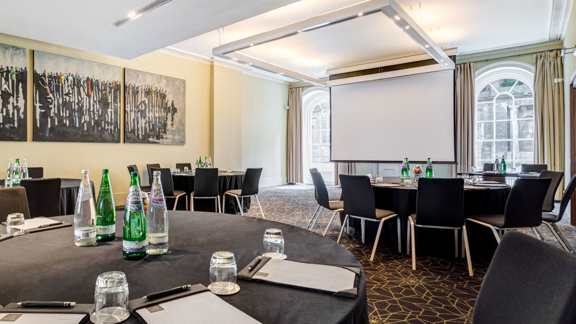 Waterloo Suite meeting room with round tables, ideal for professional events and presentations.