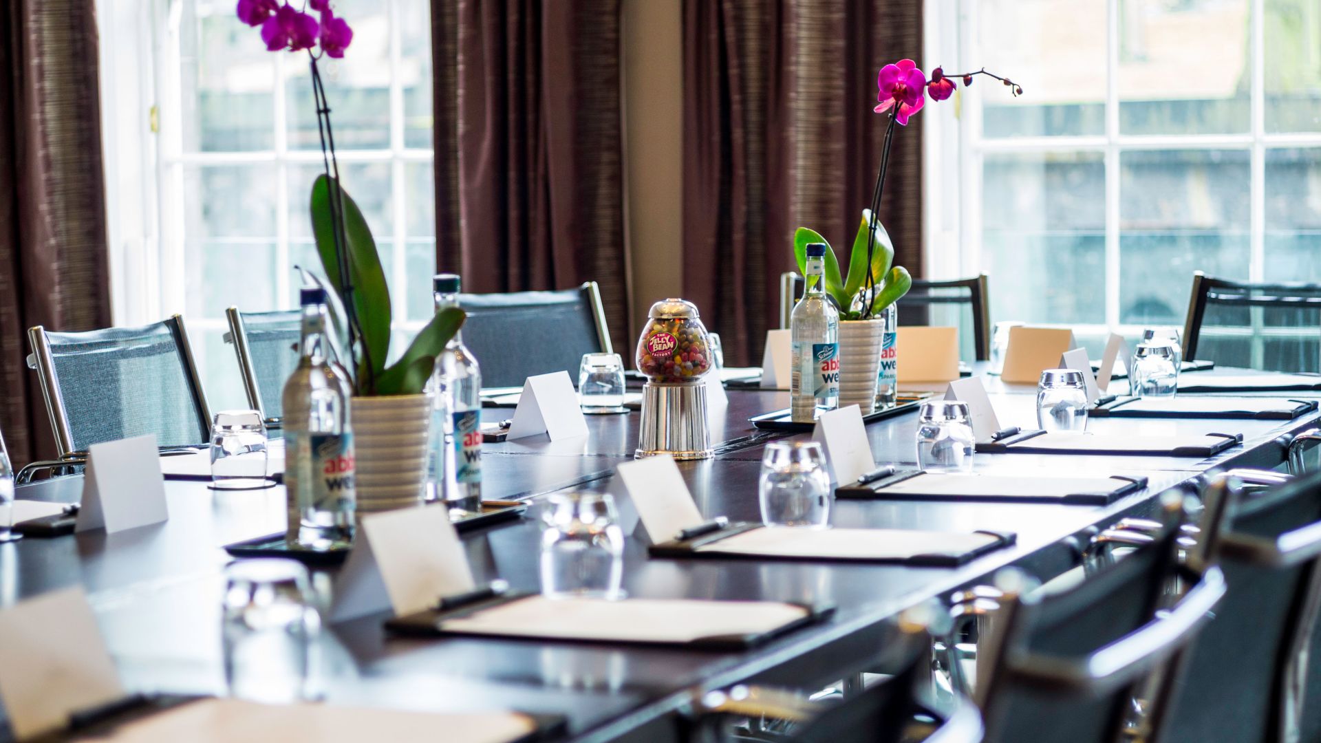 Elegant meeting room with orchids at Apex Waterloo Place Hotel for professional gatherings.