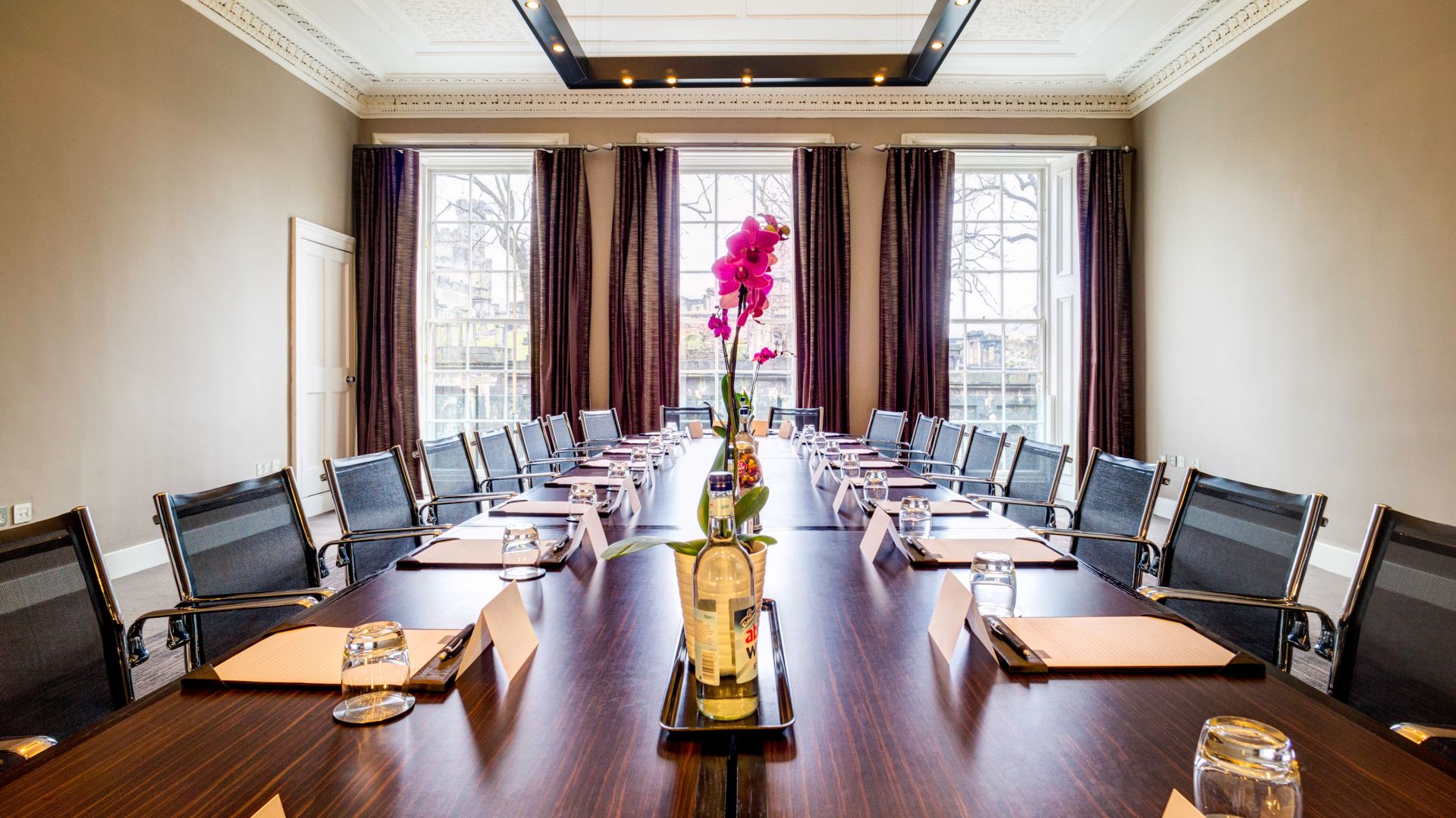 Elegant meeting room with orchid centerpiece, perfect for corporate events and retreats.