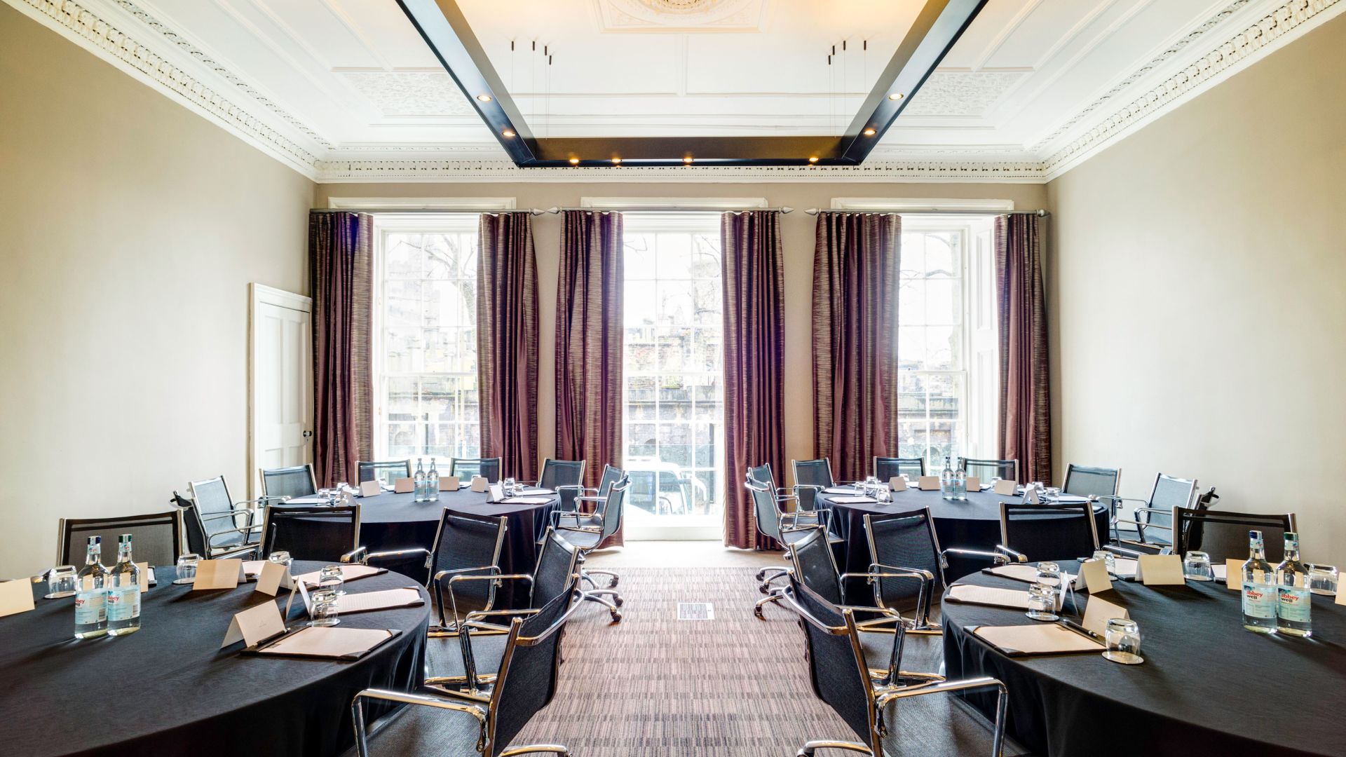 Meeting room at Apex Waterloo Place Hotel with round tables for professional gatherings.