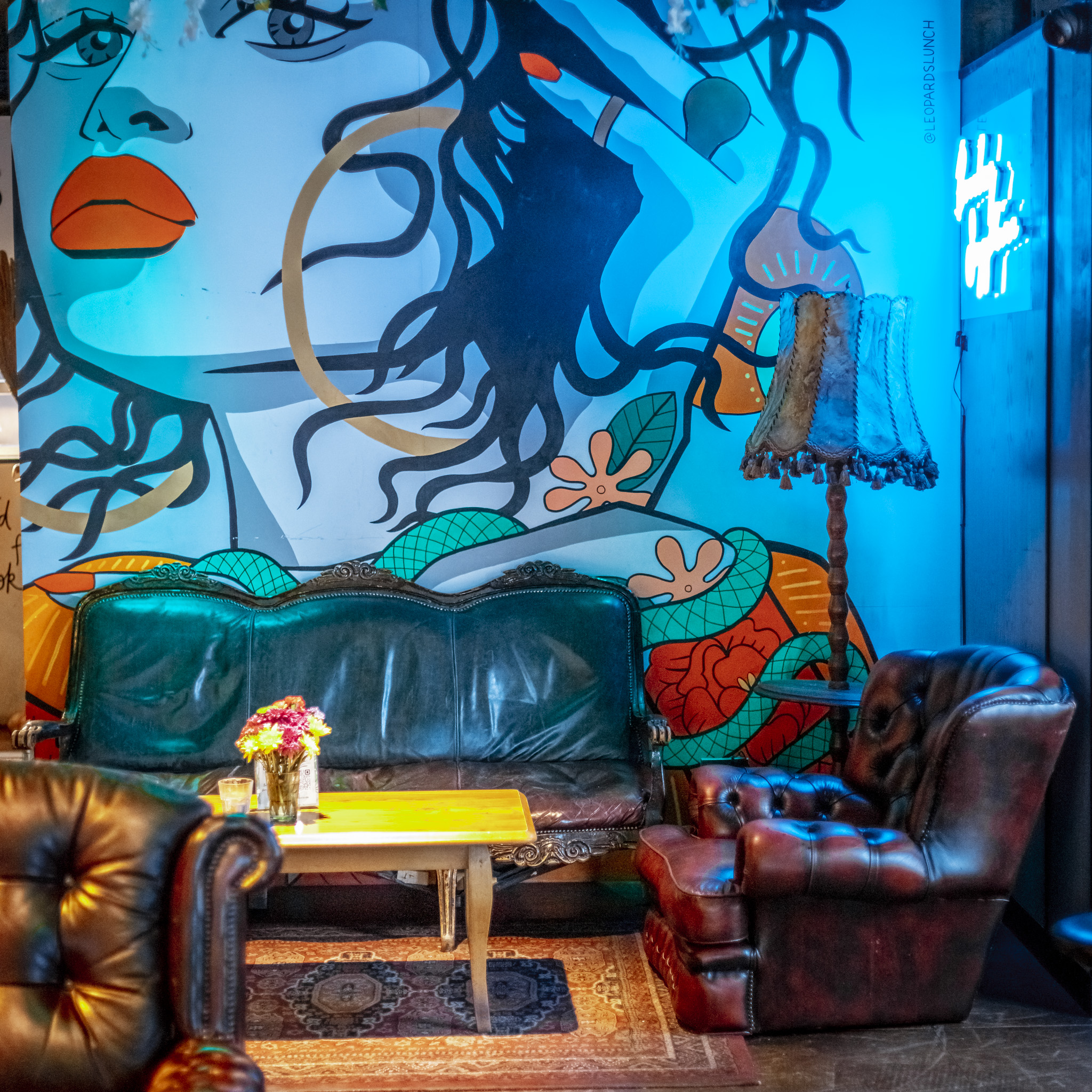 Vibrant lounge at Gigi's Hoxton with colorful mural, ideal for networking events.