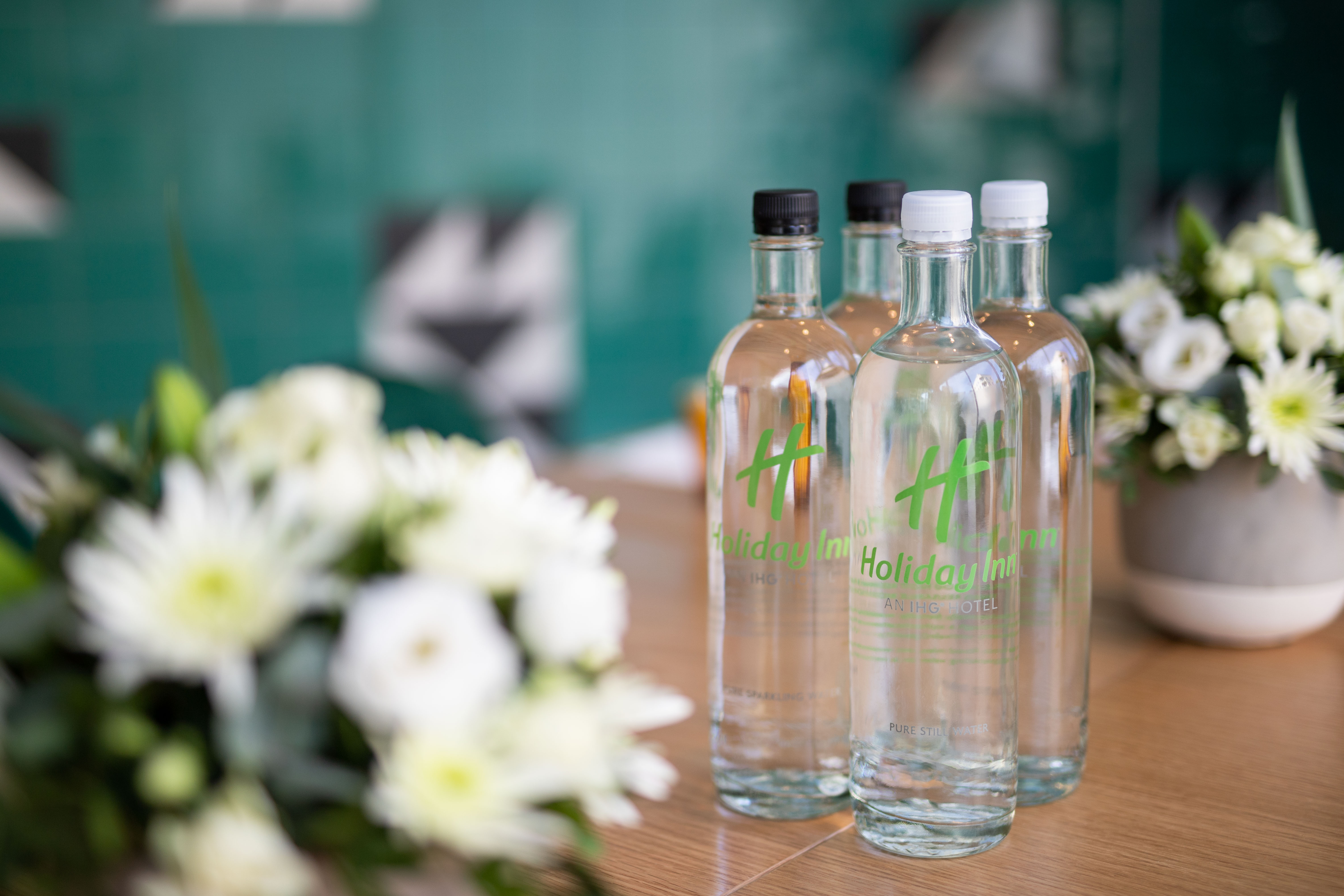 Green Room at Holiday Inn London Whitechapel with floral arrangements for meetings.