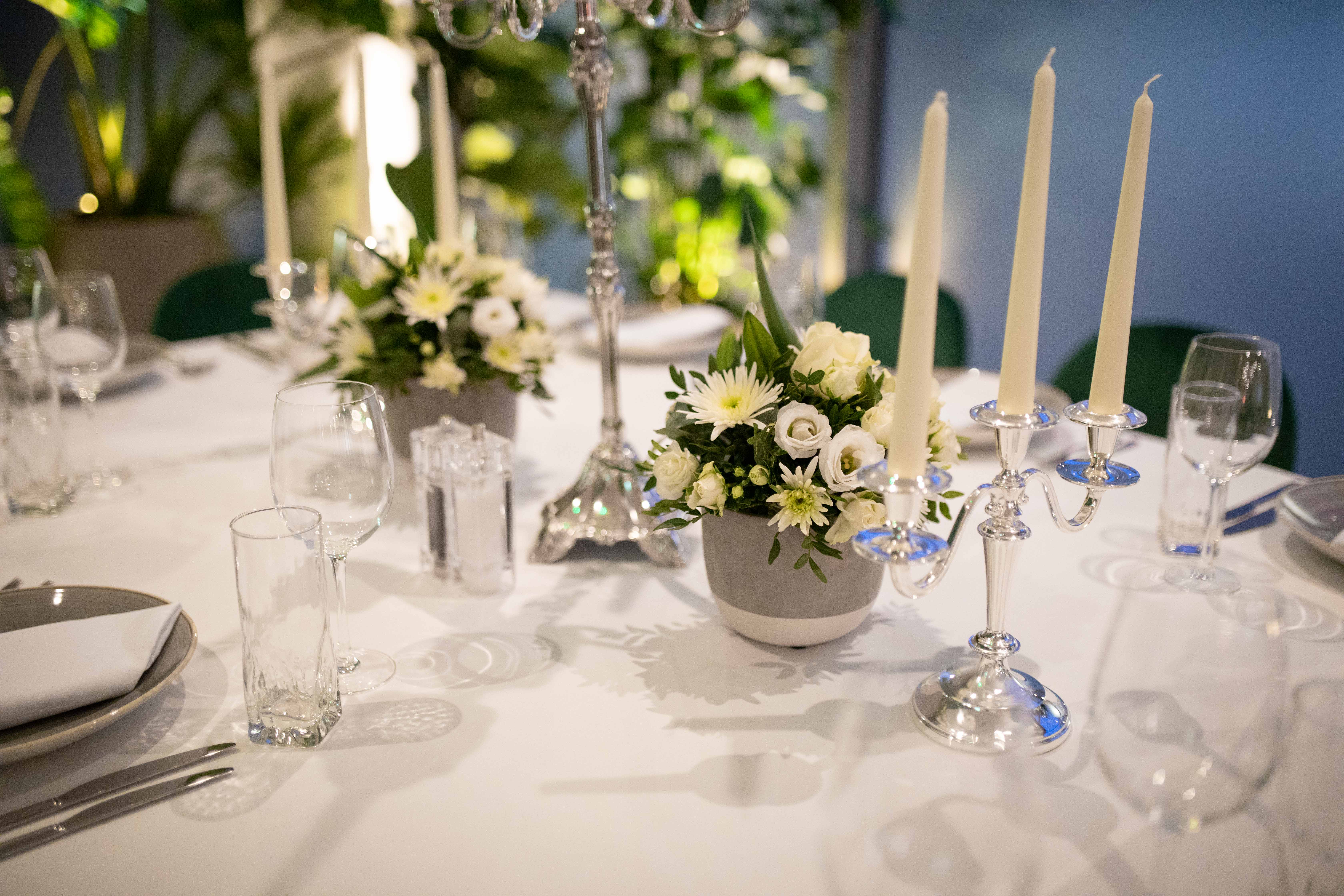 Elegant table setting with floral centerpieces at Holiday Inn London Whitechapel event.