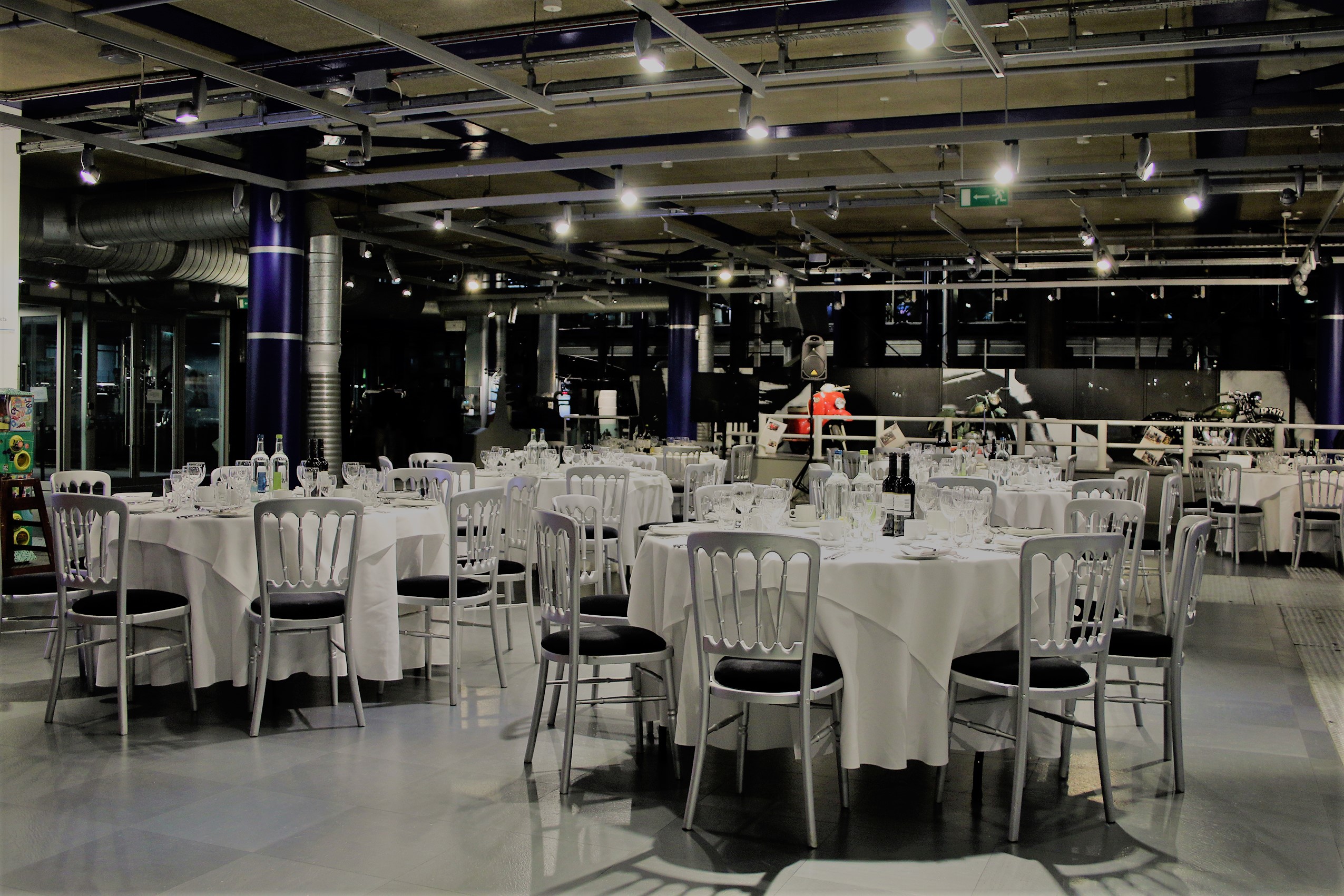 Elegant dinner setup at Past Gallery, featuring round tables and sophisticated ambiance.