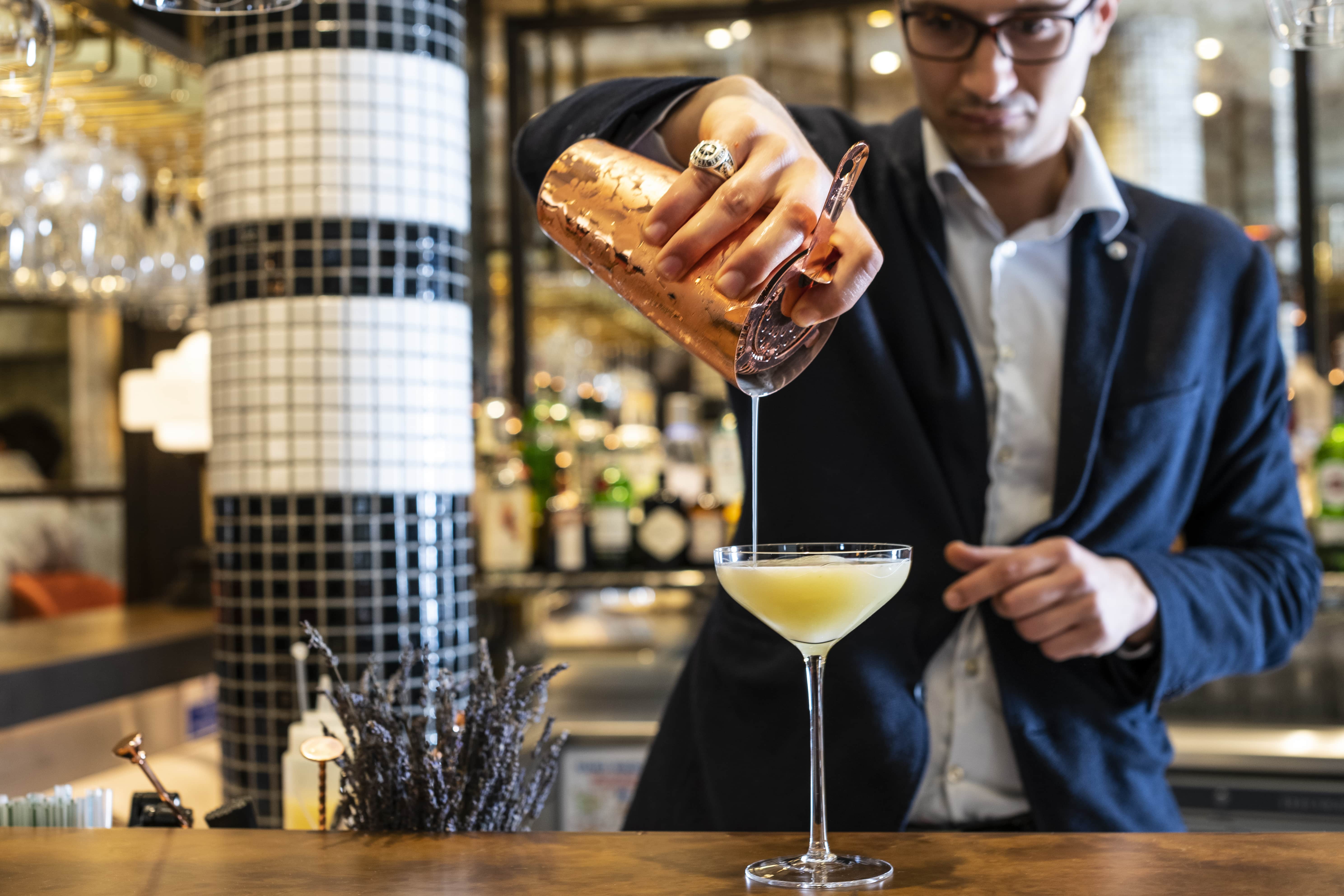 Bartender pouring cocktail at Sloane Place Bar, perfect for events and networking.
