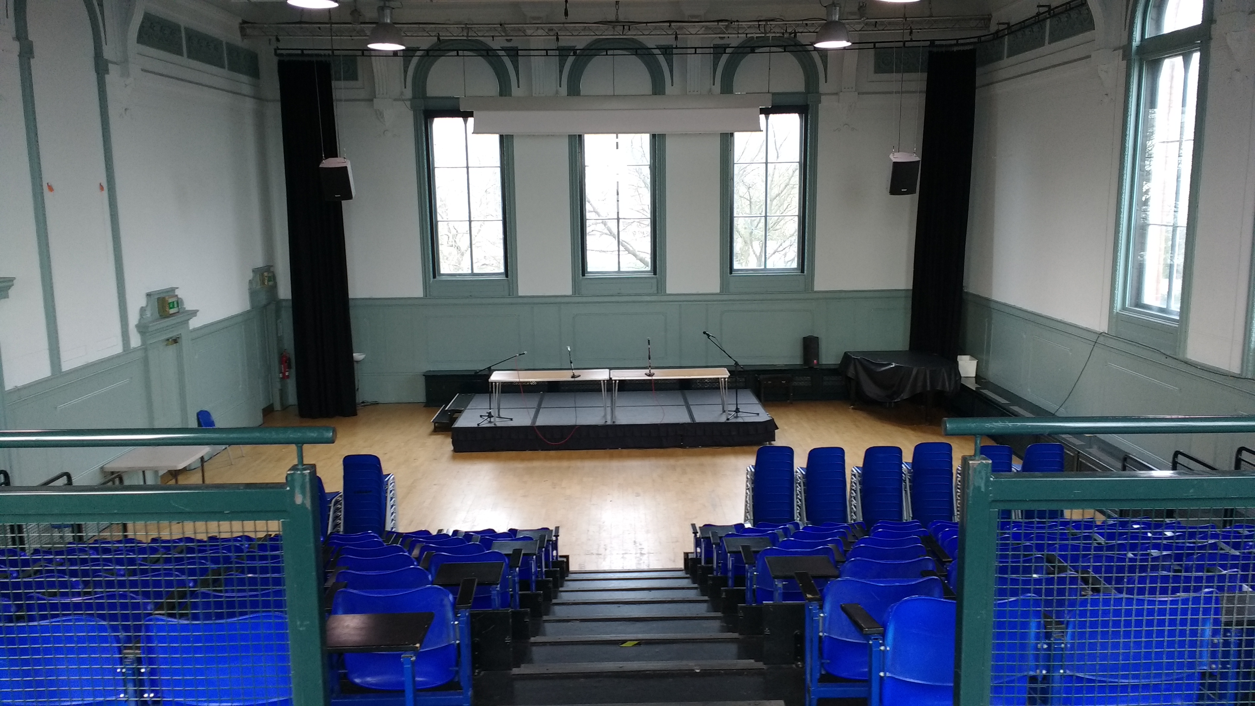 Spacious Wac Arts Main Hall with blue chairs, ideal for conferences and performances.